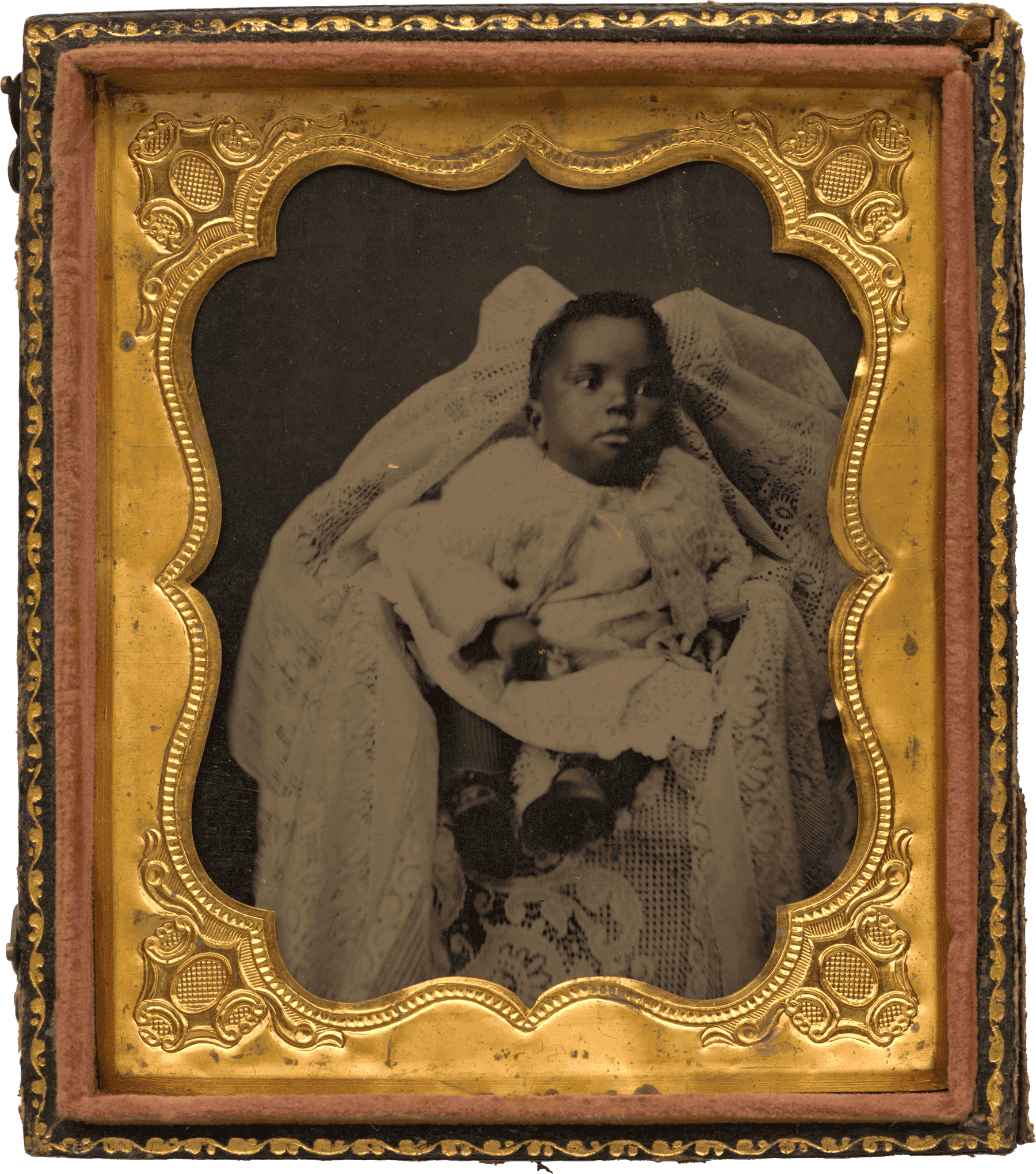 Photograph of a baby in a white lace outfit and blanket, framed in an ornate gold case.