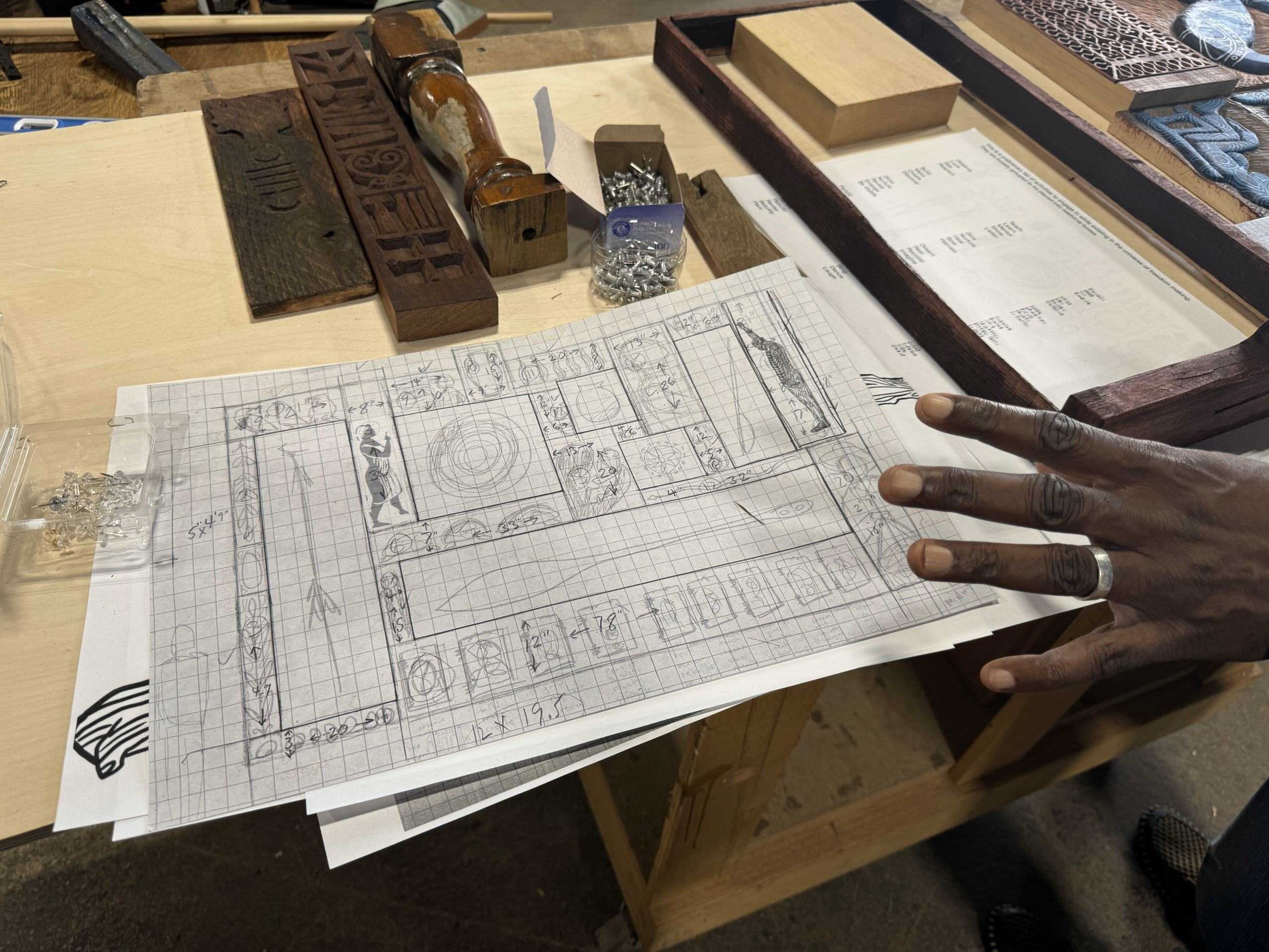 Color photograph showing exhibition drawings on a table.