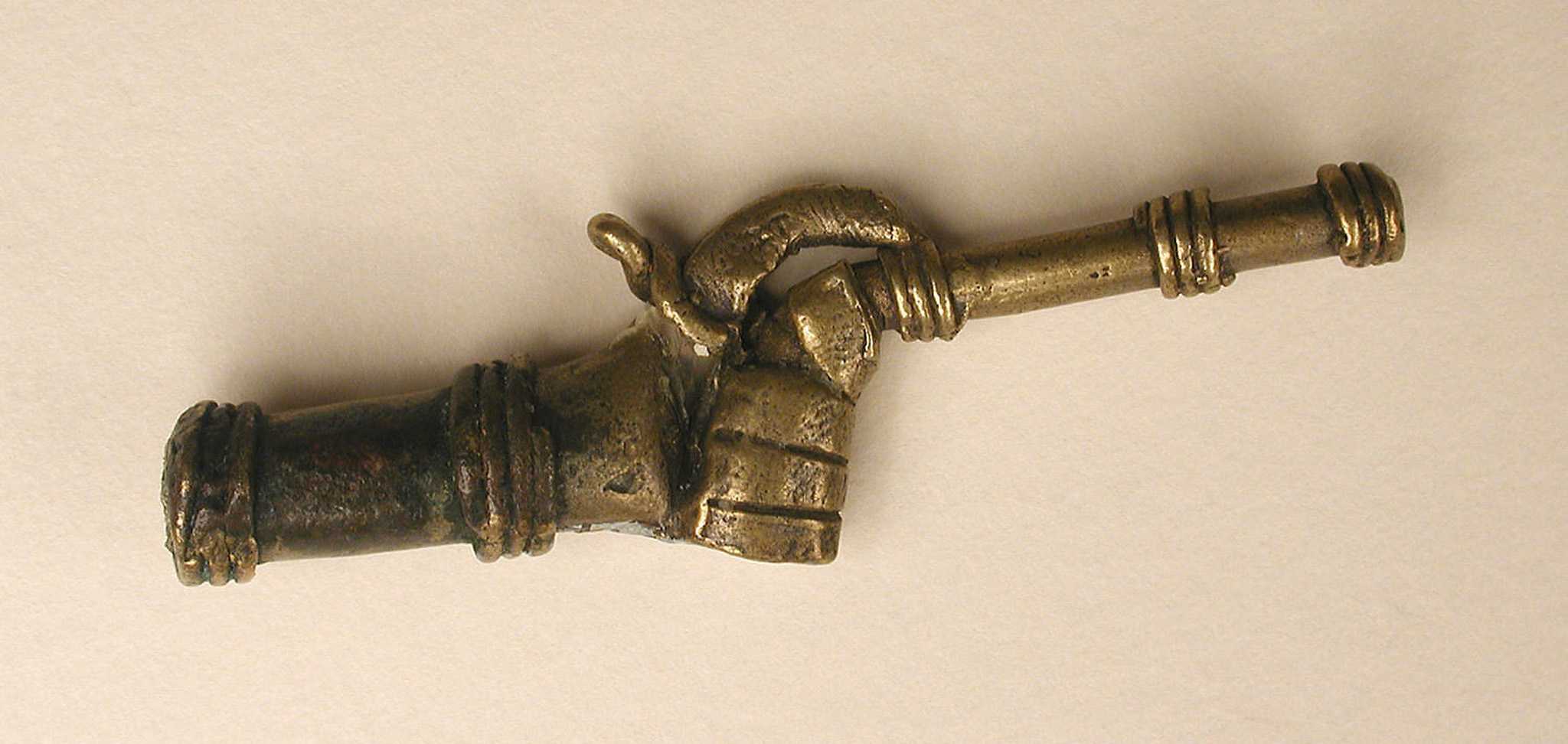 Photograph of Akan weight in the shape of a hand holding a rifle
