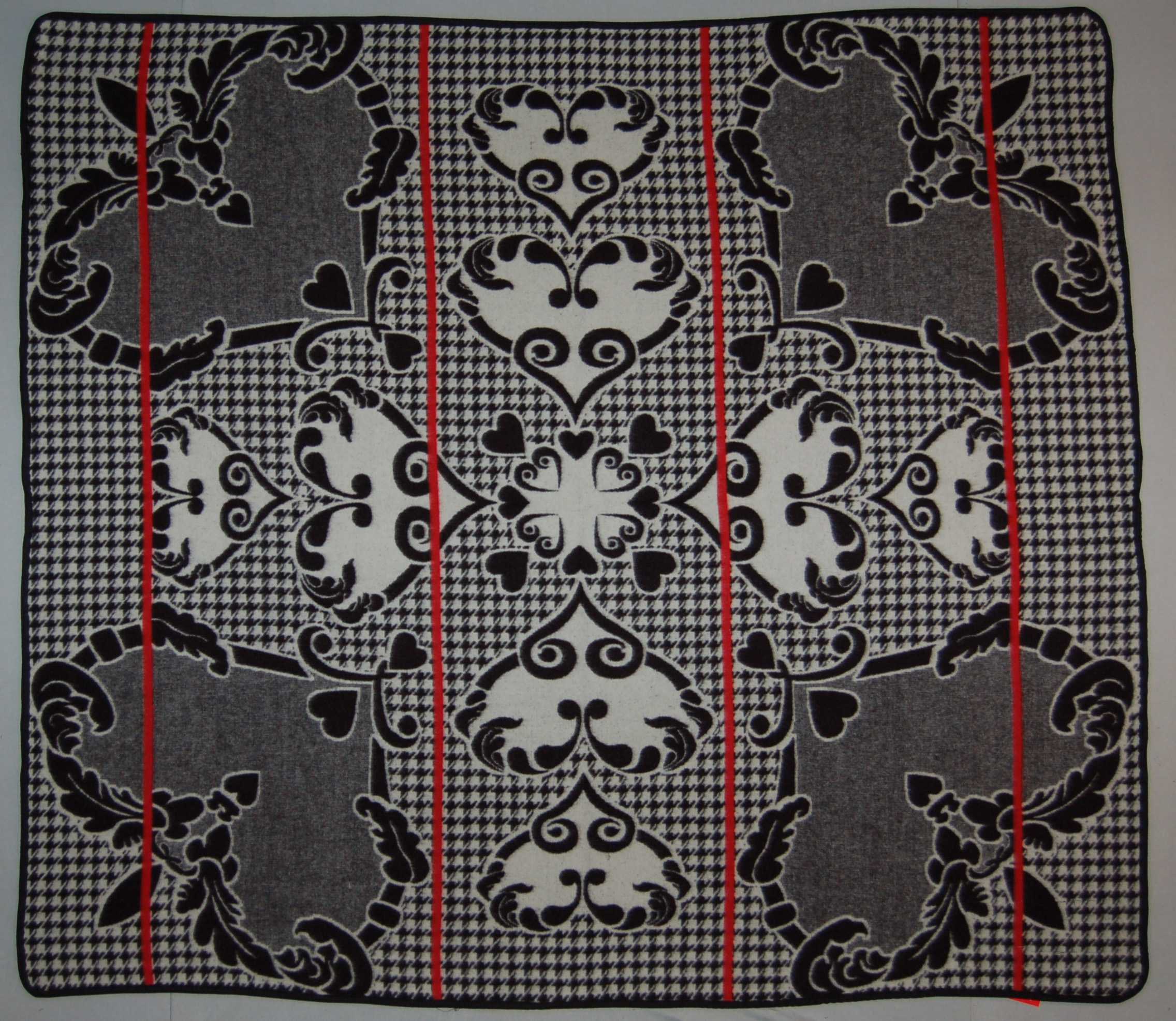 A woven blanket in the 'Khosana' design with a black and white heart pattern and pin stripes.
