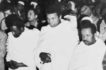 lanked by fellow pilgrims, Muhammad Ali, former heavyweight champion of the world, prays inside the Holy Mosque in Mecca during his New Year's pilgrimage to the spiritual center of the Moslem world