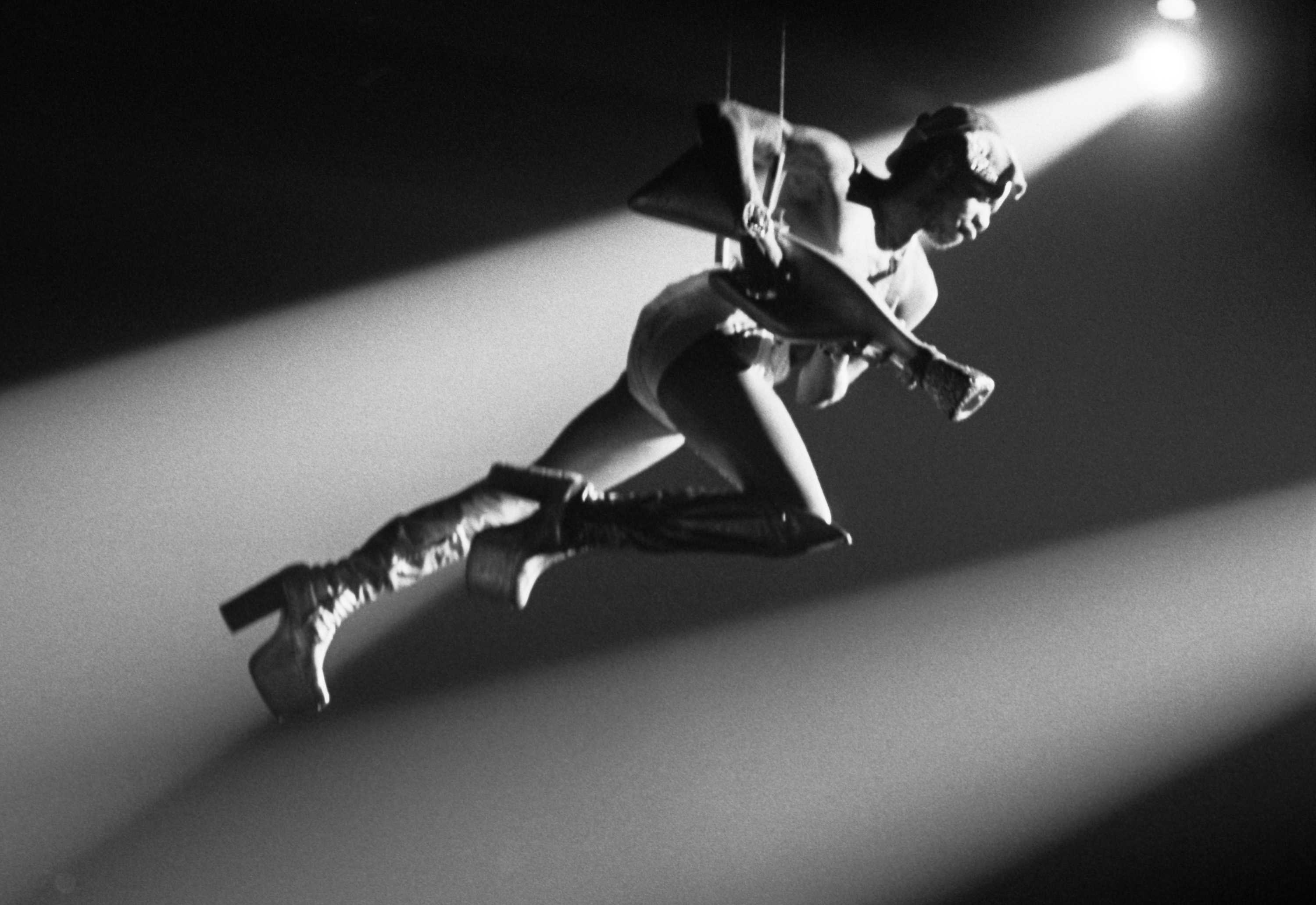 Garry Shider performing as Starchild while being suspended in the air in a black and white photo.