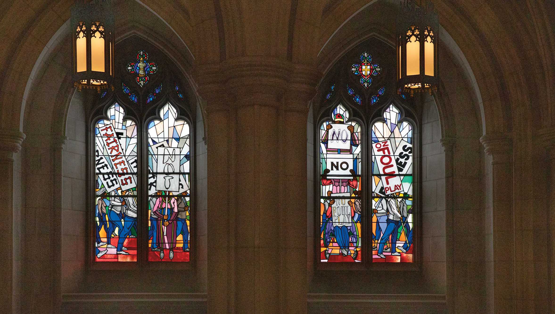 Two stain glass window depicting people protesting hate and advocating for fairness.