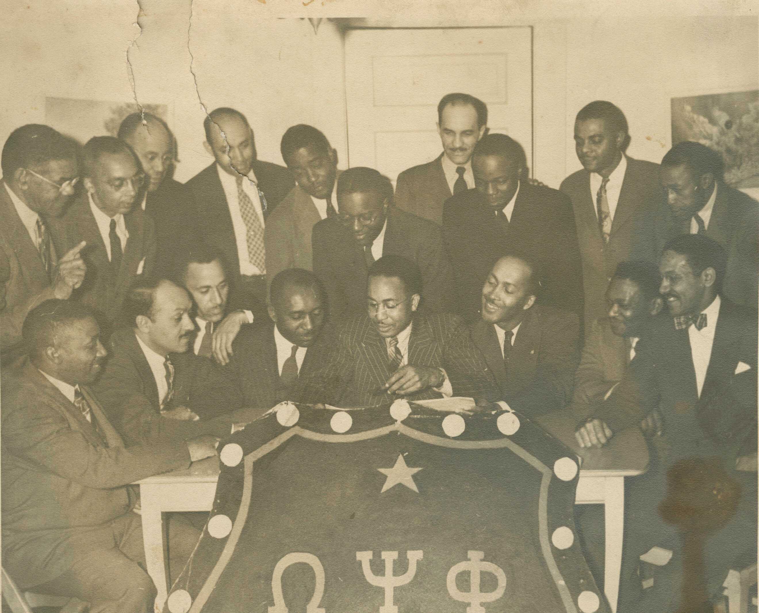 A black and white photograph of eighteen graduate chapter members of the Tau Omega Chapter of Omega Psi Phi Fraternity, Inc.