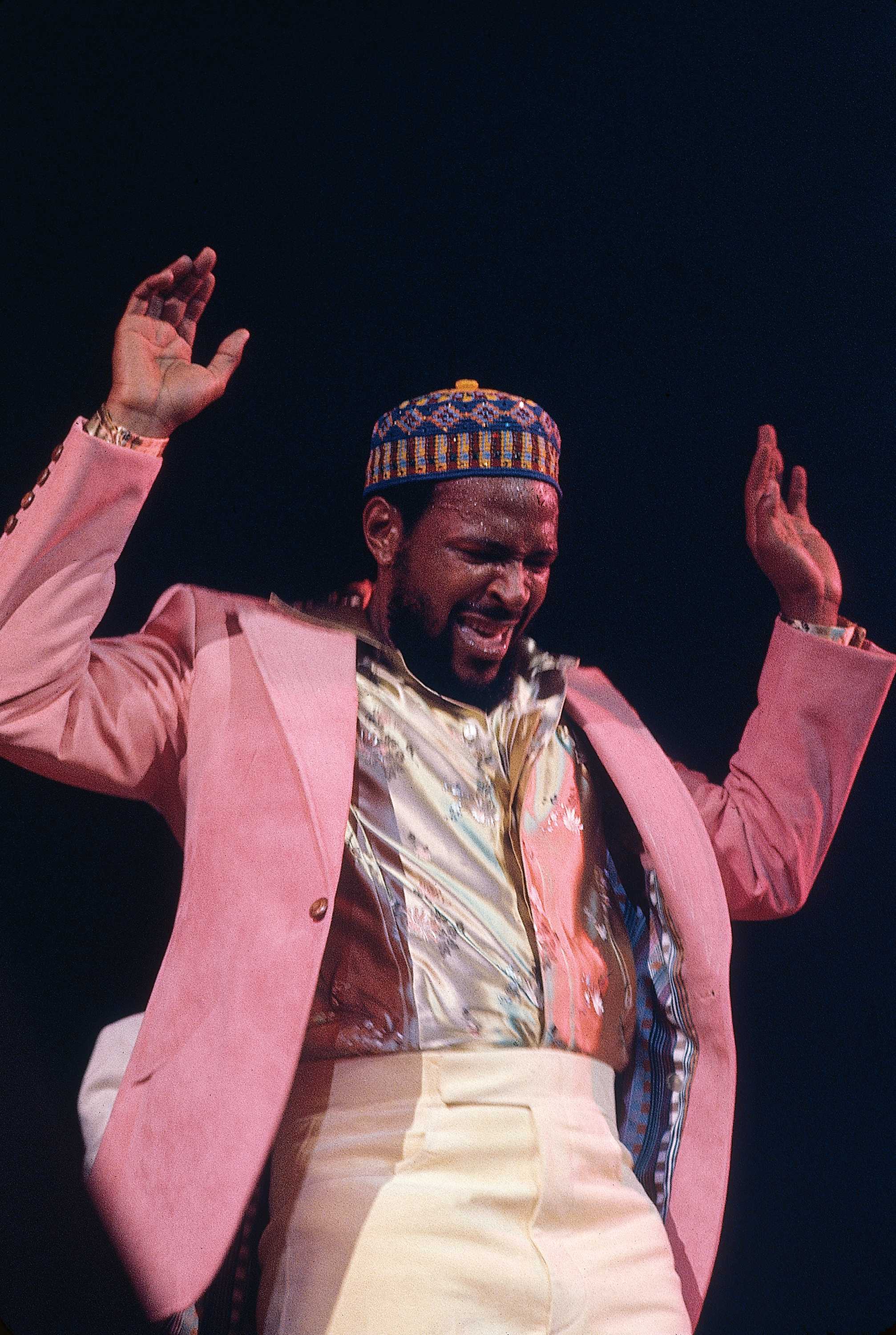 Photograph of Marvin Gaye in a purple jacket on stage performing