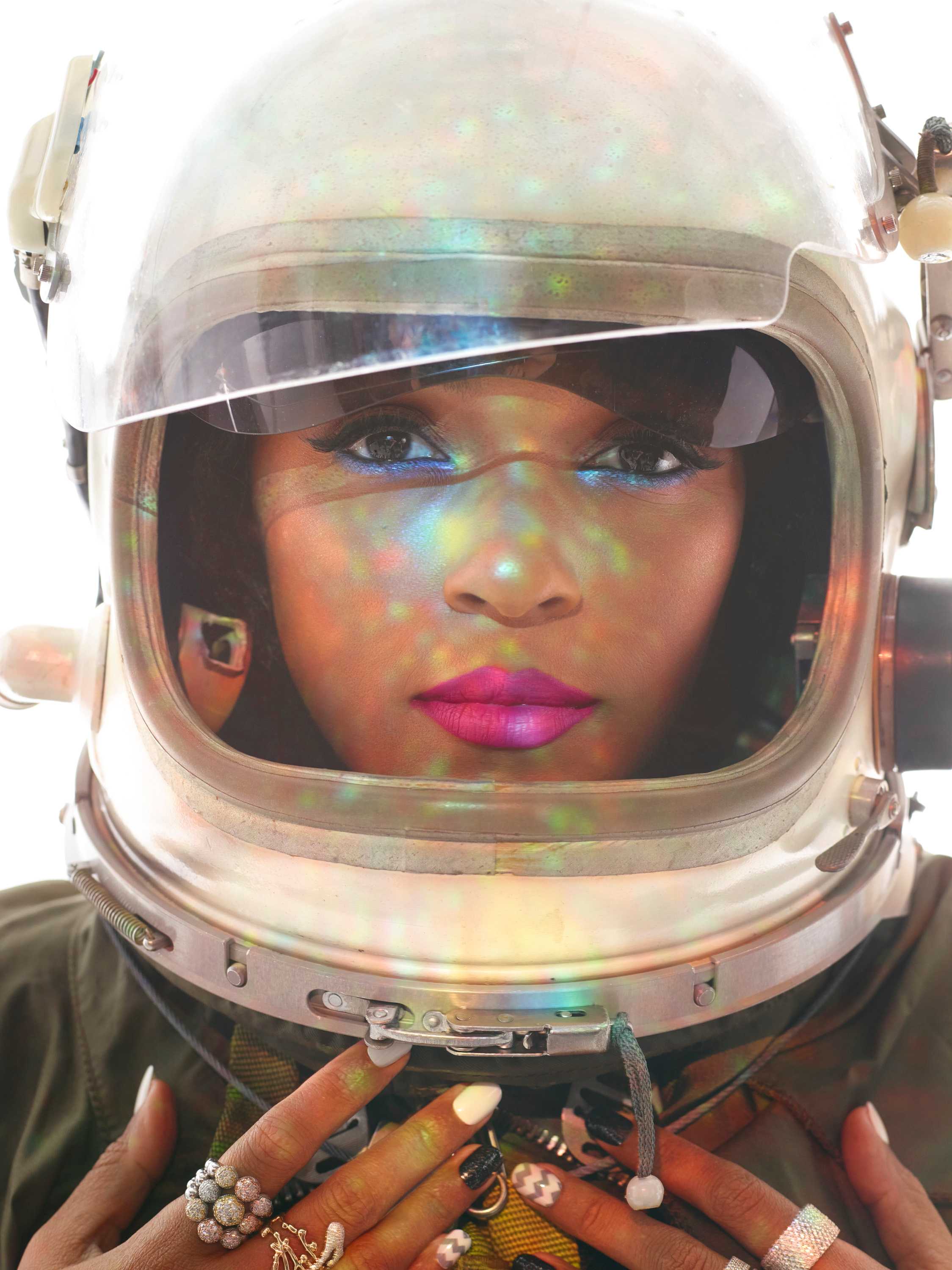 A close shot of Janelle Monáe wearing a space helmet and pink lipstick in a futurist look.