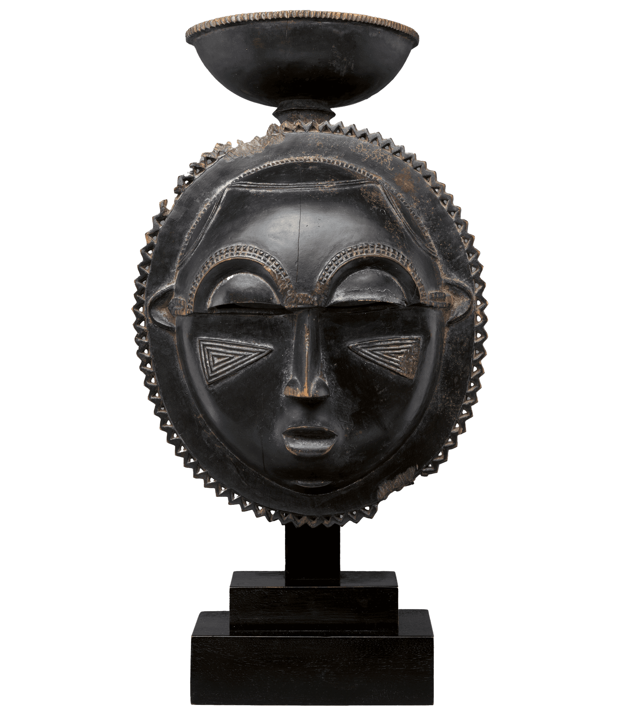 A dark colored moon statue sits on a plain backdrop. The moon has a face and structural design elements.