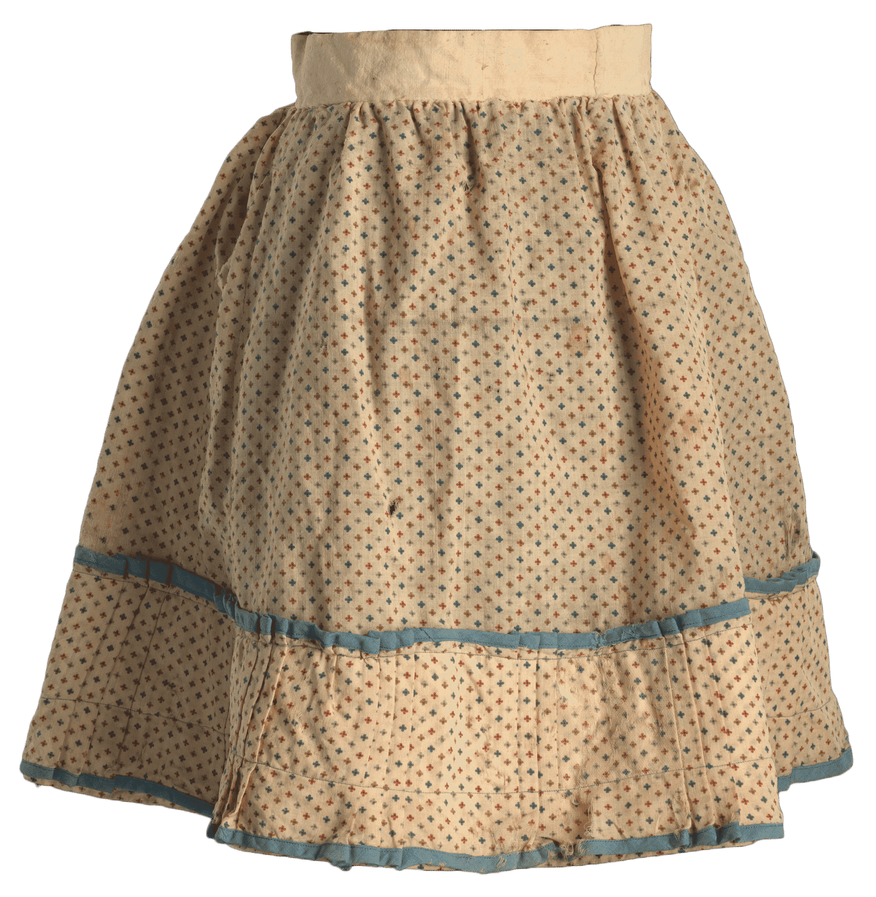 A child's circular skirt in a floral print with a pleated flounce on the hem. The main fabric is a plain weave natural fiber fabric with a cream ground and a repeating pattern of small four-petal flowers in red, purple, blue, and tan. The skirt is predominantly hand-sewn. It has a waistband made from an undyed bast fiber fabric with the floral print gathered and whip stitched to the waistband. The skirt is more closely gathered on the back. There is a slit at the center back that divides the waistband completely. There is no attached closure method, but rust staining at the back opening of the waistband suggests the skirt was pinned to close. The bottom of the skirt has an extra flounce of the floral print that has a series of pleats around the skirt in sets of three alternating with straight sections. This flounce is machine-sewn at the top and 1 1/2 inches from the bottom using blue thread that is possibly a synthetic fiber. The bottom and top edges of the flounce are bound with blue fabric sewn on the bias. The interior of the skirt is lined only behind the extra flounce with a hand-pinked undyed bast fiber fabric. There is a previous repair on the back proper right side of the skirt where a panel of light brown synthetic fabric is hand sewn on the interior of the skirt from the gathering at the waist to the top of the older linen lining on the bottom.