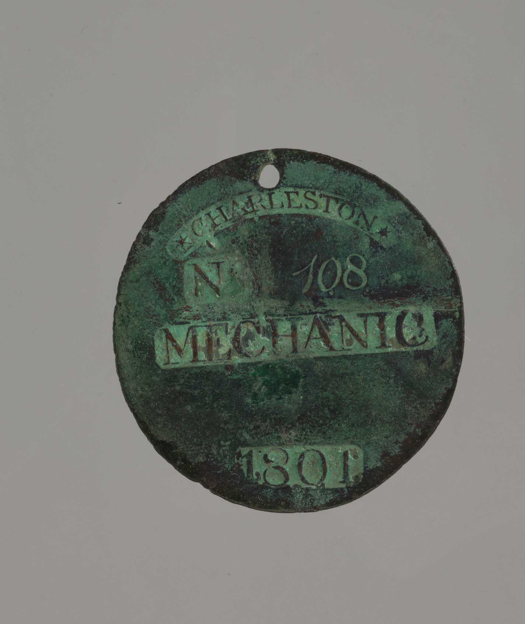 Photograph of circular copper slave badge.