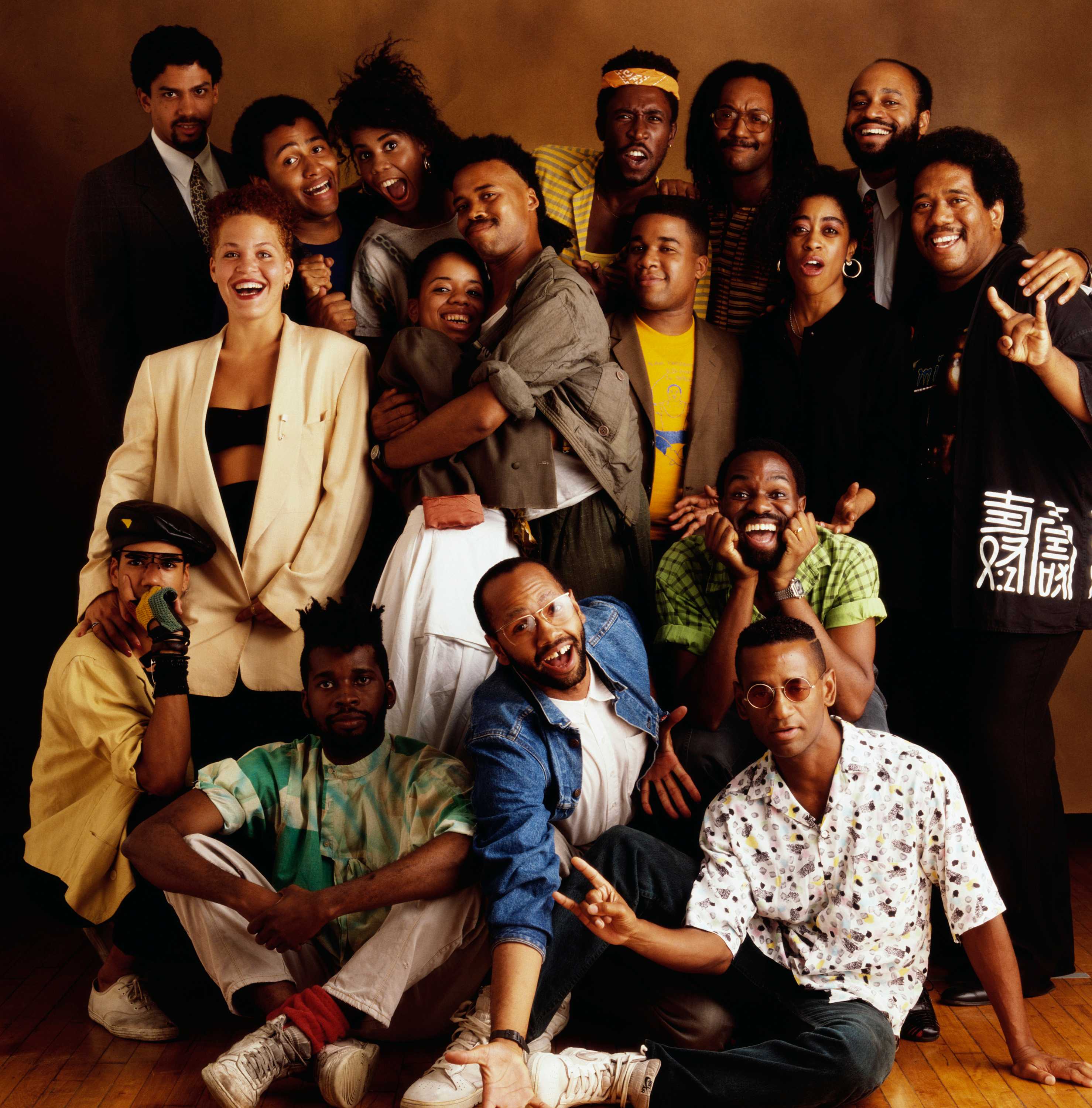 A color photo of entire band of Black Rock Coalition against a brown background.