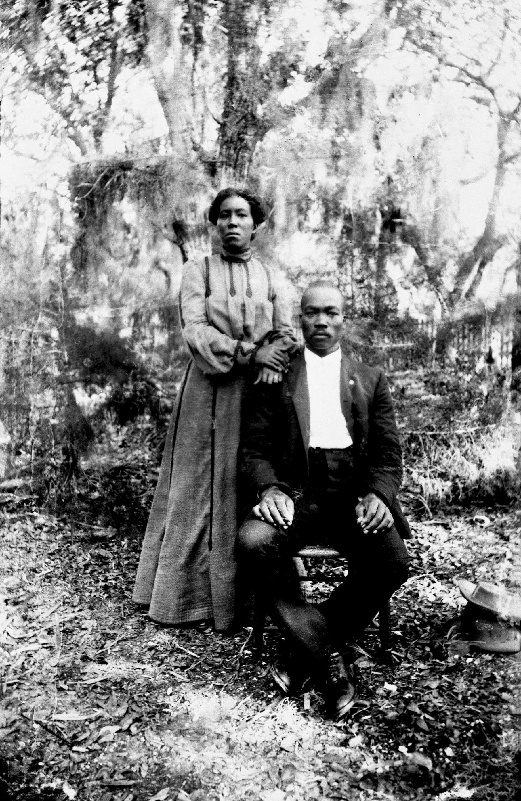 A black and white photo of a couple posing for a portrait after their backyard wedding.