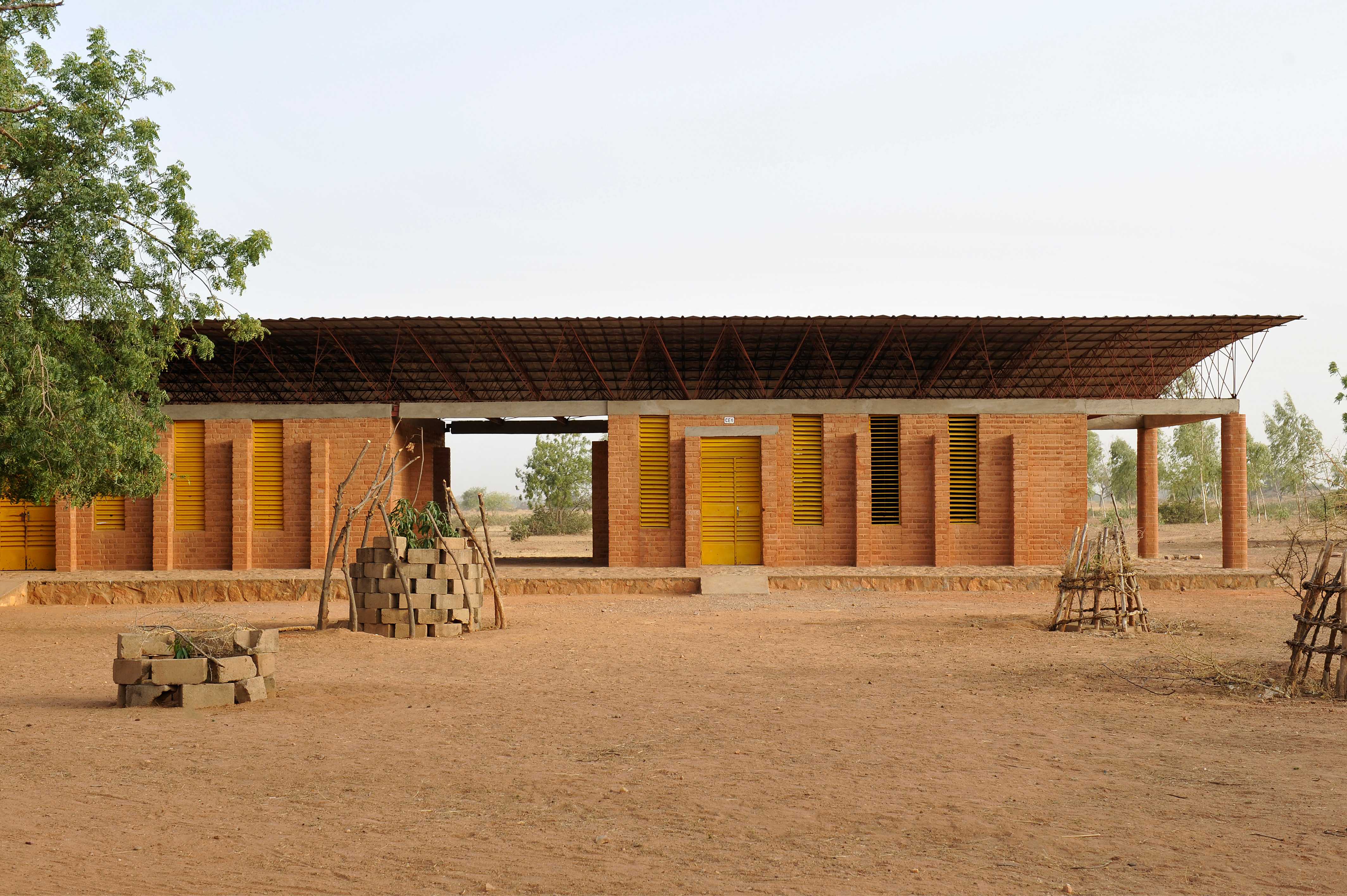 The rendering of the Gando Primary School, which is a single level brick columns and angled wooden roof.