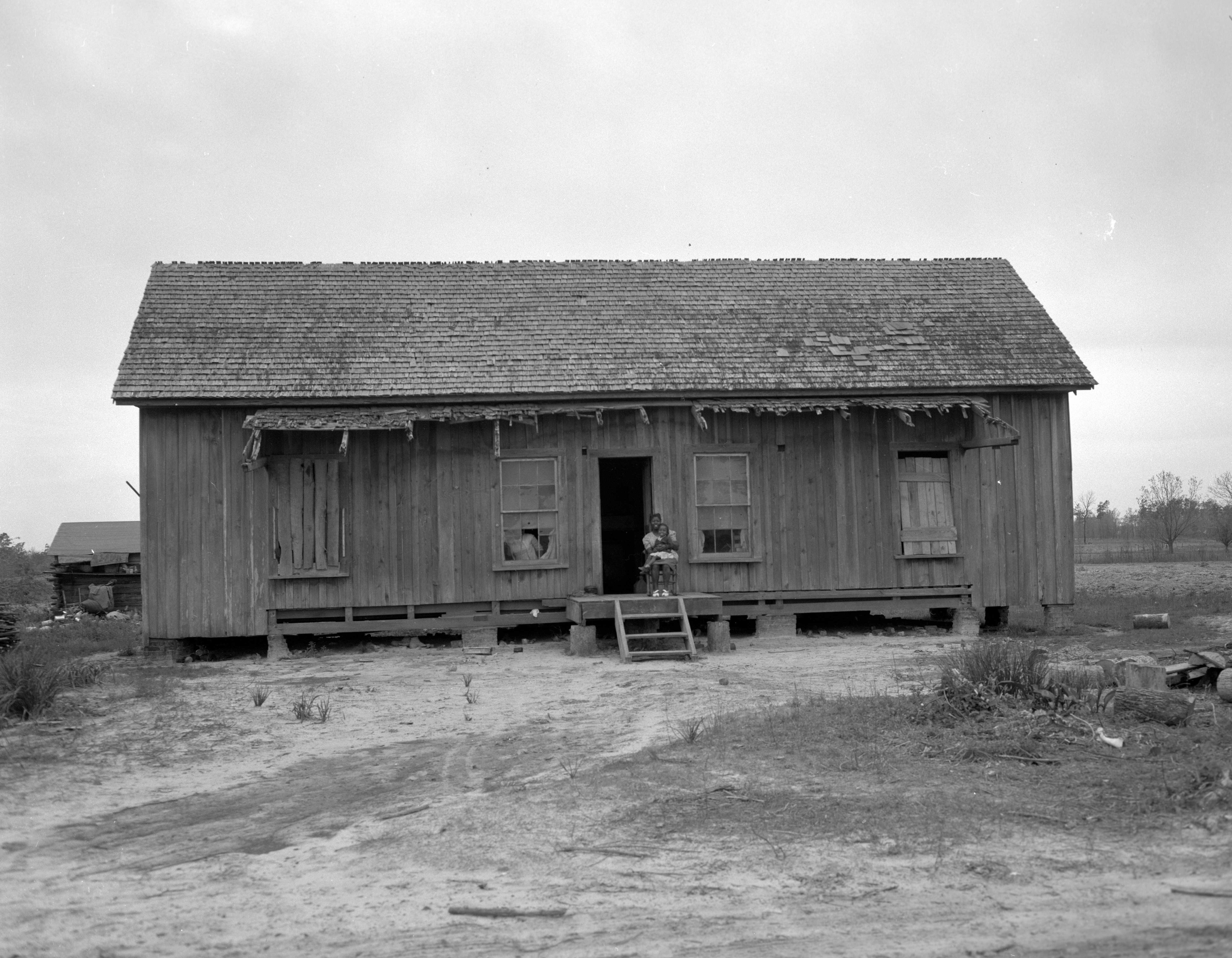 Black and white photograph of small wooden house