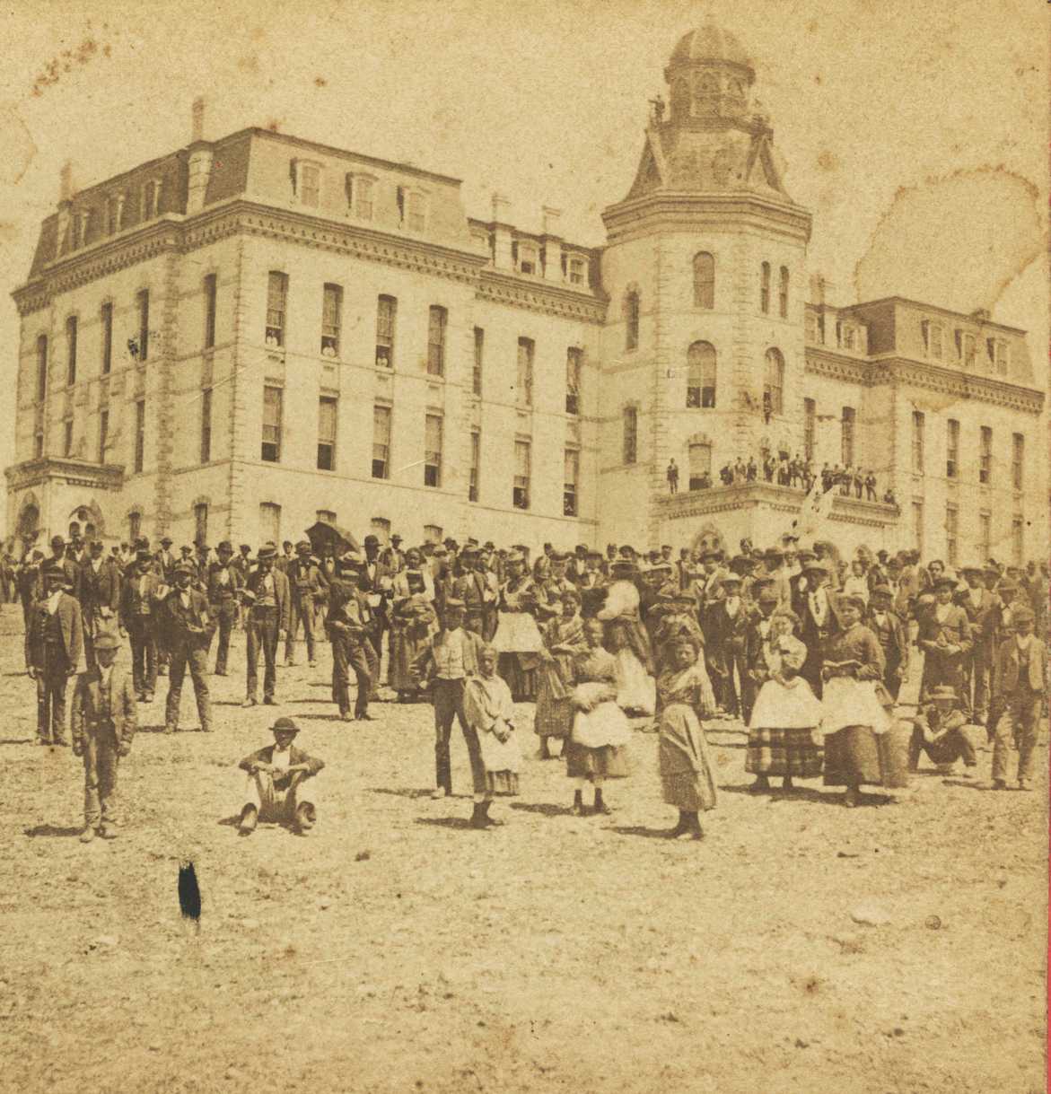 A sterograph produced by C. W. Woodward of people outside the Main Building housed the university’s administrative offices and served as the Freedmen’s Bureau headquarters.