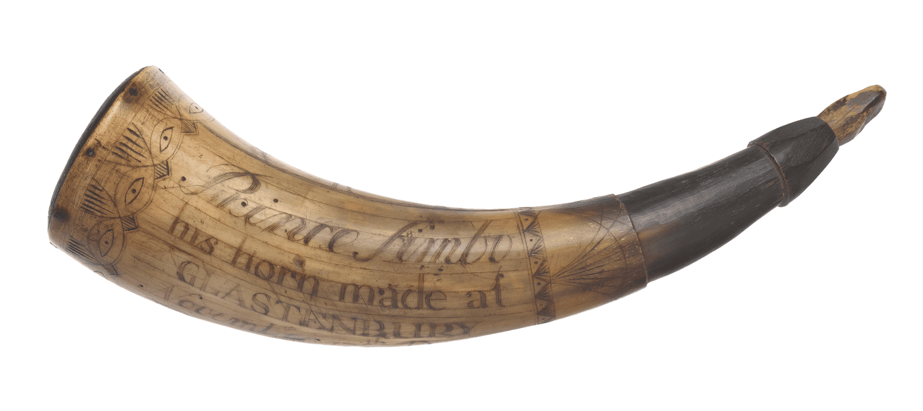 An engraved powder horn with stopper. The ox horn is carved with images of a dove carrying a banner reading "LIBERTY," a deer, the sun with a face, and a pine tree. An intricate design featuring eyes encircles the outer edge of the horn. The name Prince Simbo and the date November 17, 1777 are also engraved on the horn.