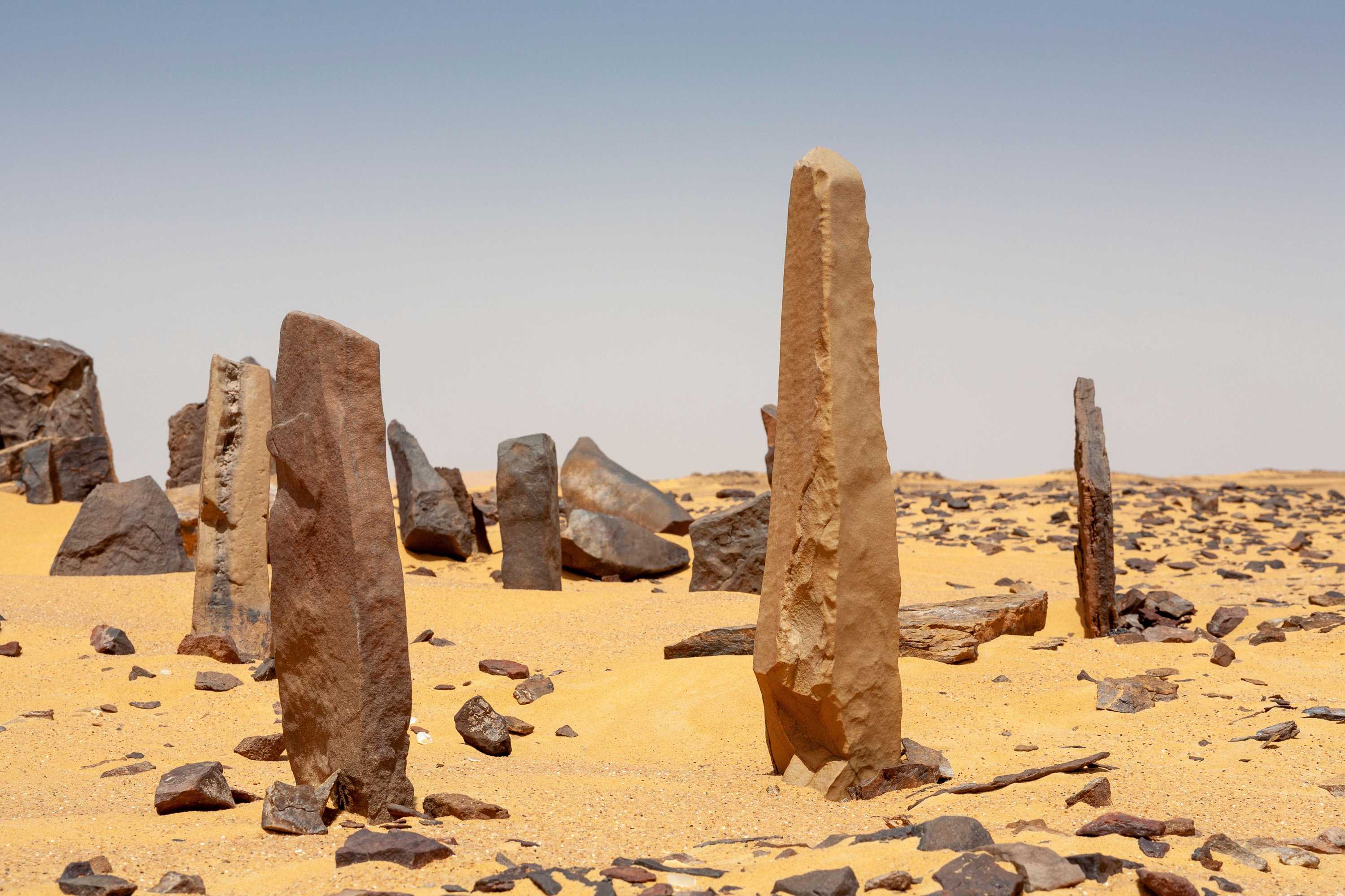 Large thinner stones stick out of the sand to create the Calendar Circle. Many smaller rocks lay next to them.