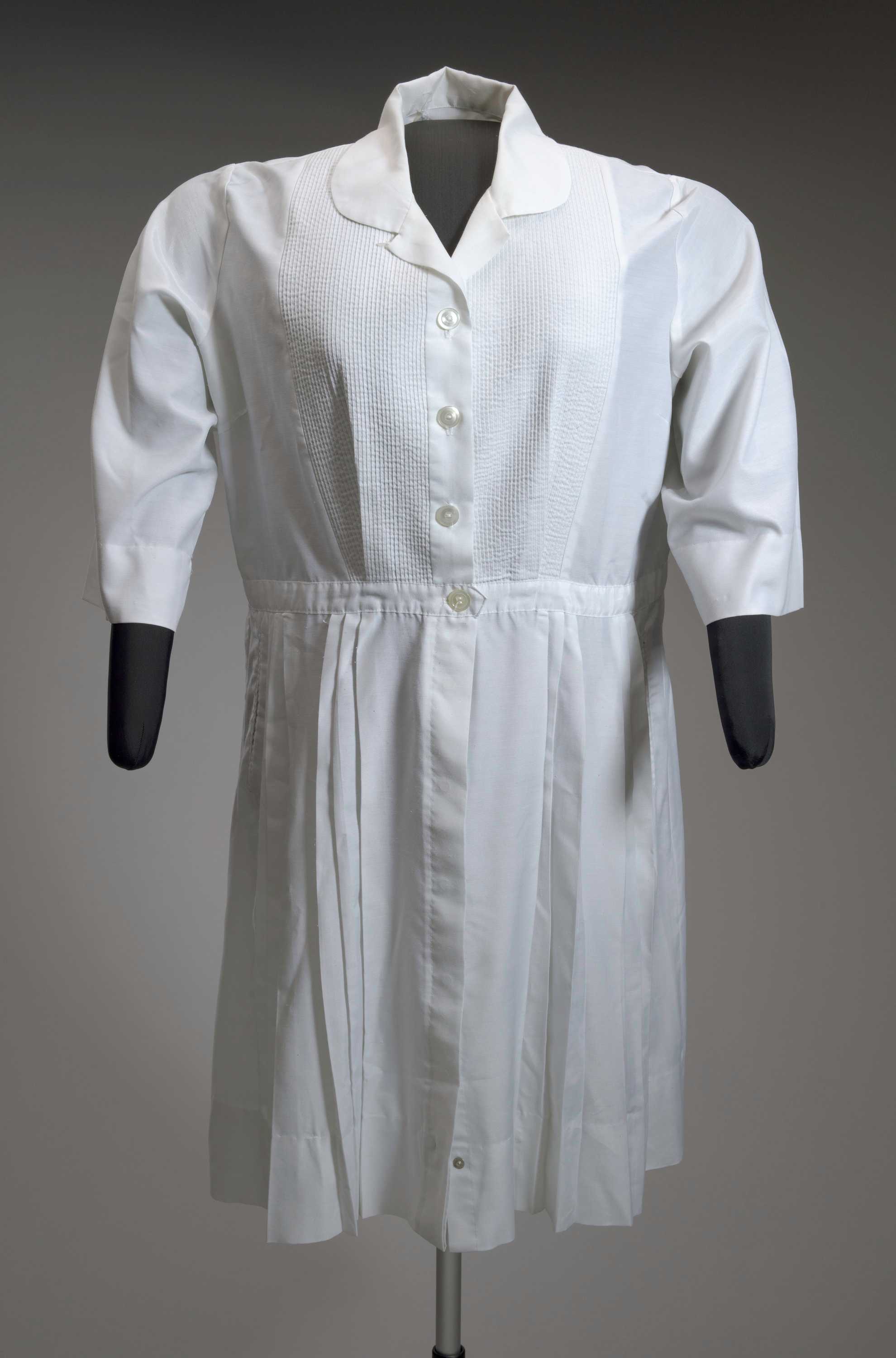 A white midwife's uniform overdress worn by Amanda Carey Carter.
