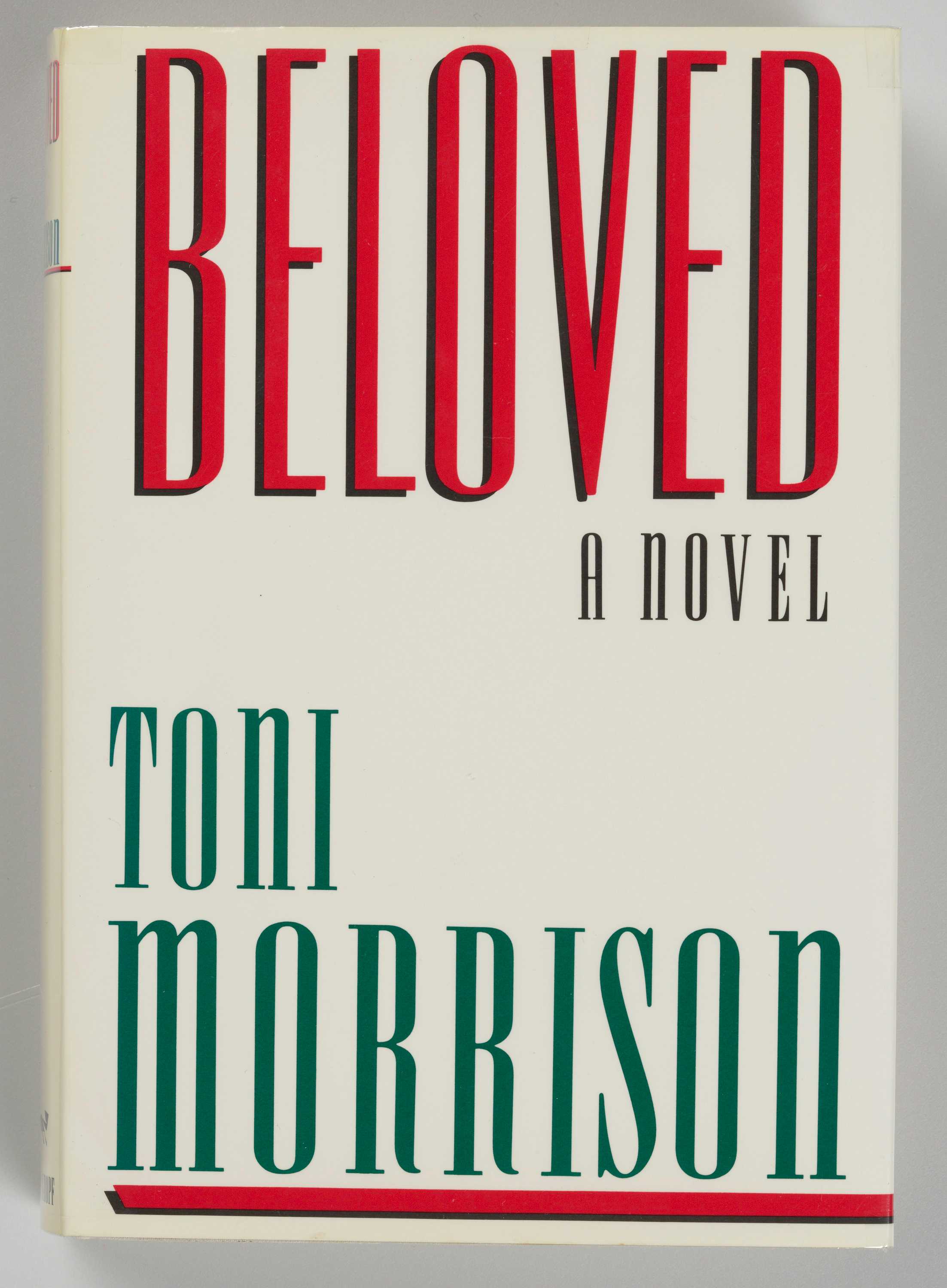 Image of the book cover of Beloved: A Novel by Toni Morrison. The text on the book has the title and author's name in red and green text on a white background.