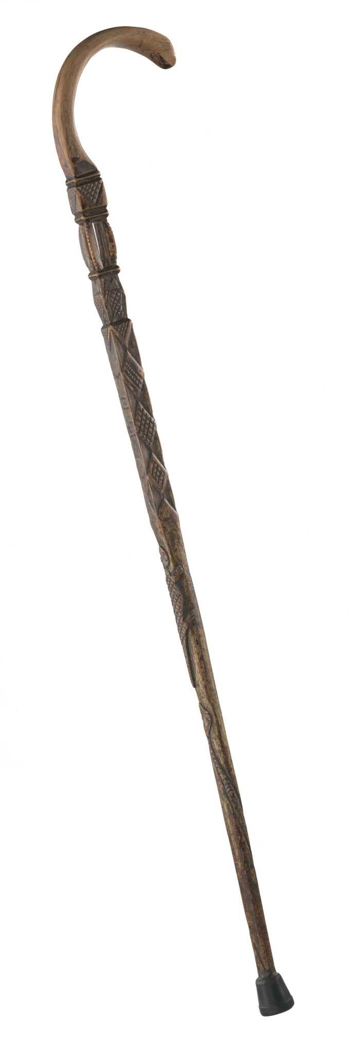 A carved wooden walking cane owned by Sen. W.B. Nash. The length of the cane is cylindrical at the bottom but squared off about halfway up. The cane has been incised over much of its surface with geometric and animal decorations, including diamonds, fish, snake and lizard. [19  11] is carved on the outward facing side of the cane. Near the head of the cane is a carved chamber with four curved posts inside which rolls a loose wooden ball. The top of the cane is curved, pale and very smooth from use. At the handle of the cane handle is another incised section, a geometric design or possibly letters. There is a black rubber piece, not original, adhered to the foot of the cane.