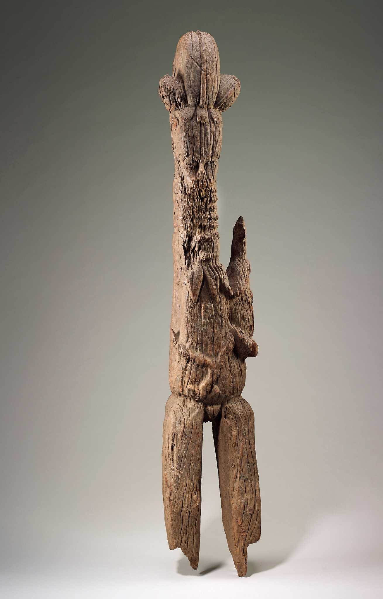 A carved wooded figure of a female with child. The child is attached to the female on it's right hip.