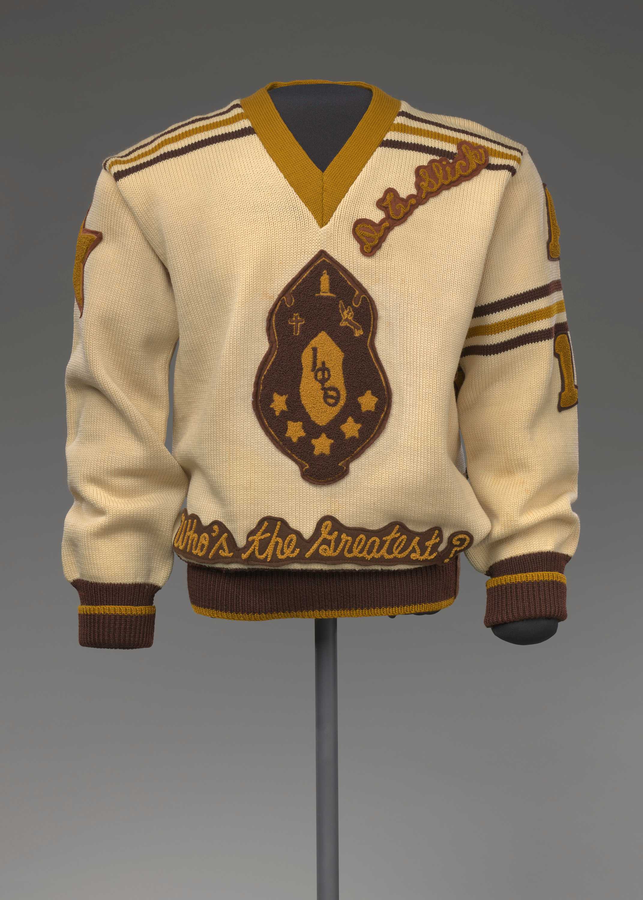 A brown, gold, and beige knitted pullover letterman sweater for the Iota Phi Theta Fraternity.