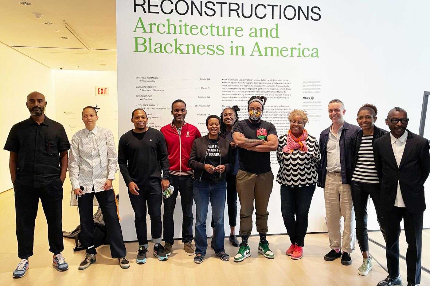 Members of the Black Reconstruction Collective stand outstide of an architecture exhibit, posing for a photo.