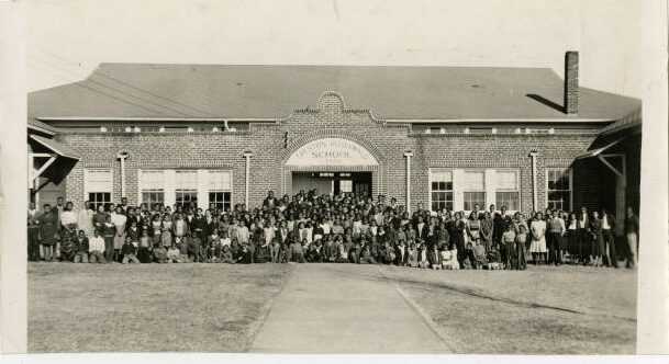 Photograph of people in front of school