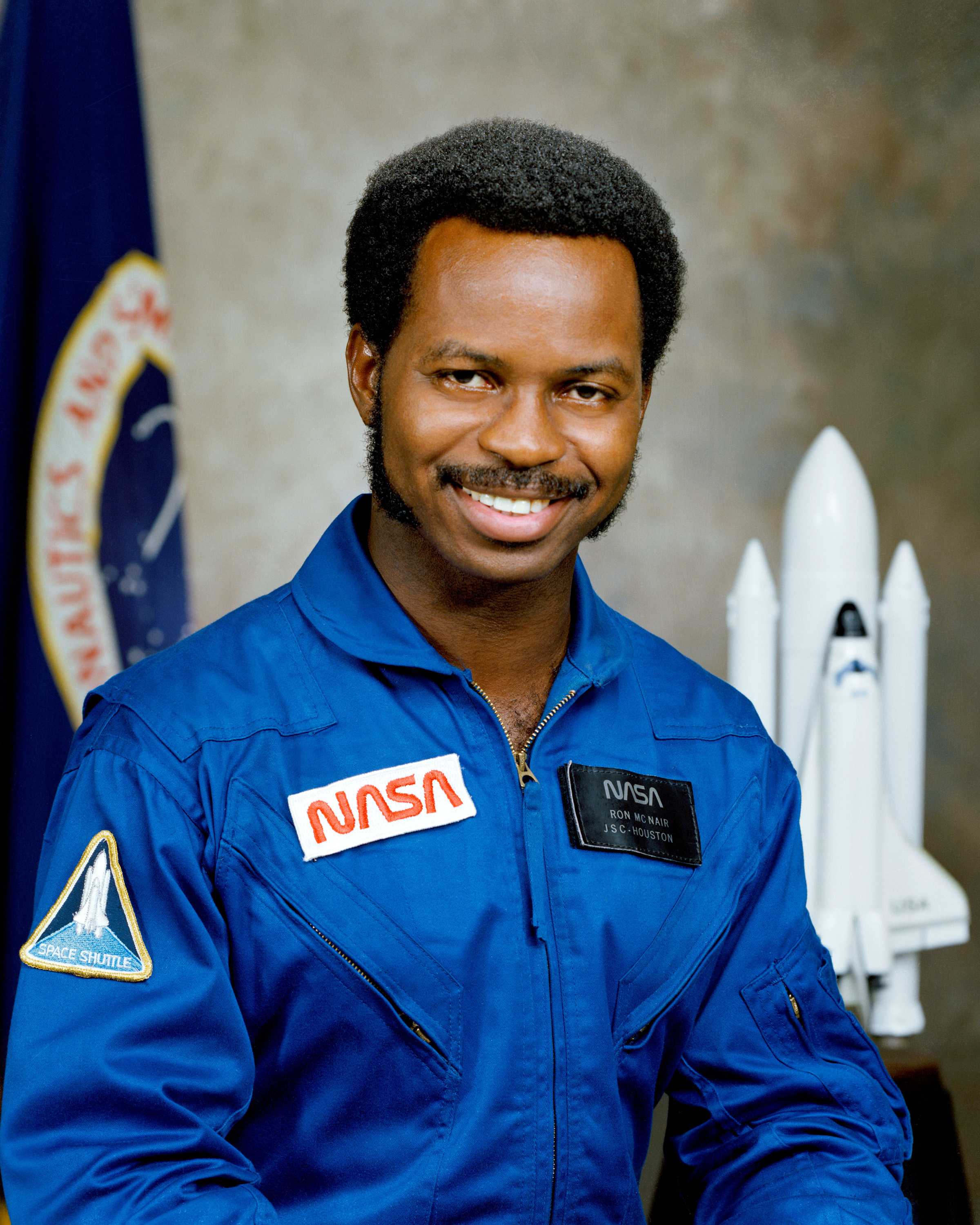 Ronald McNair is wearing a blue NASA uniform and looking directly at the camera with a confident expression.