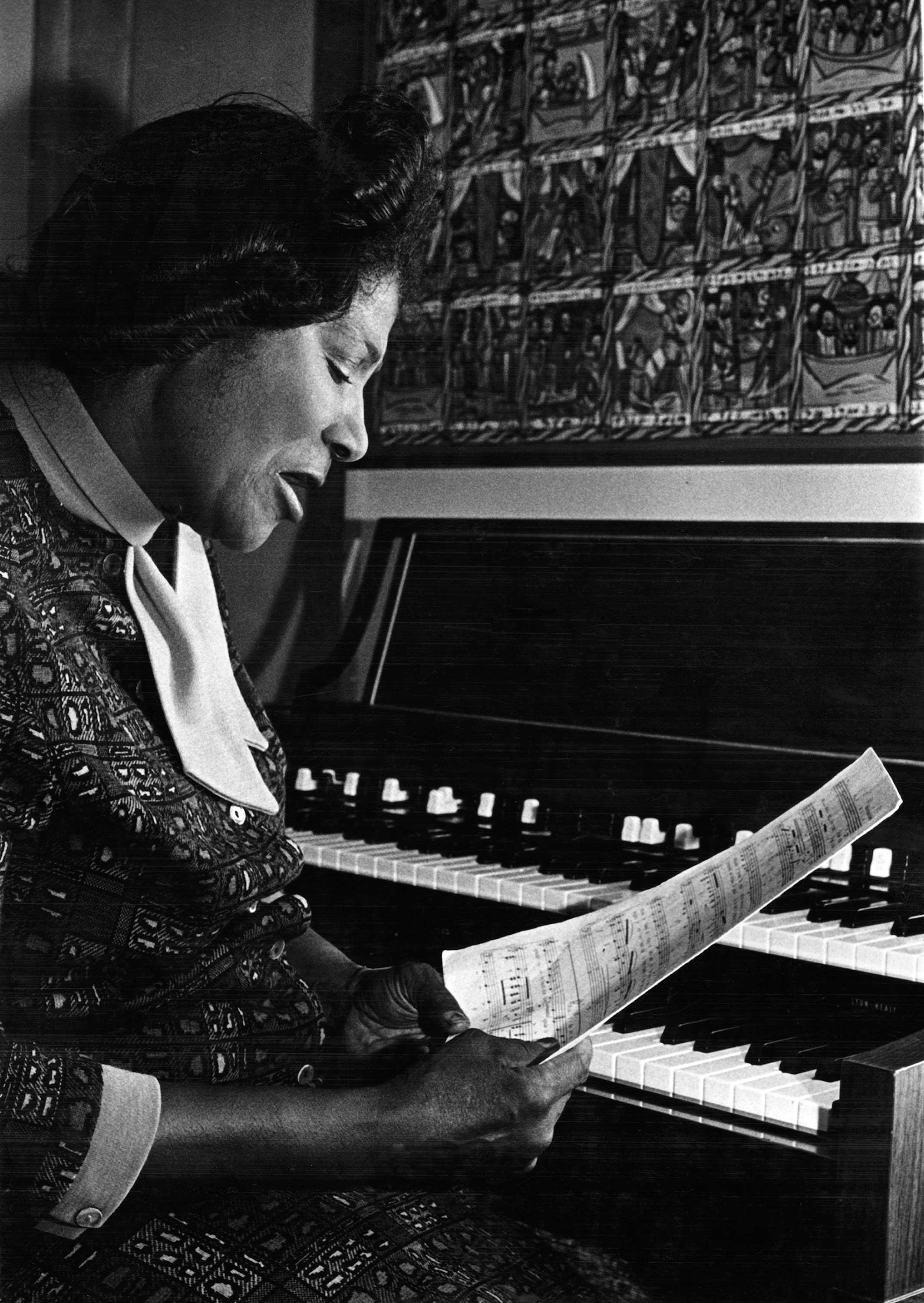 Black and white photograph ofMahalia Jackson studying music at home