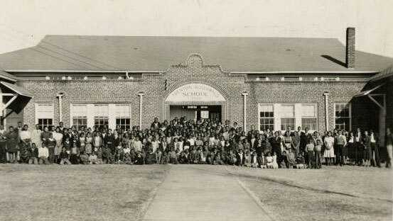 Photograph of people in front of school