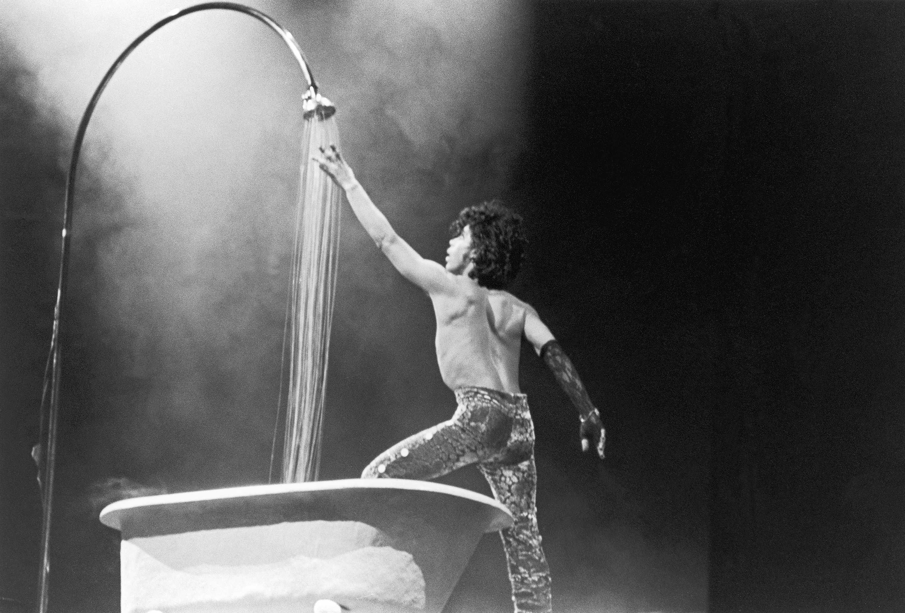 Black and white photograph of Prince performing on stage