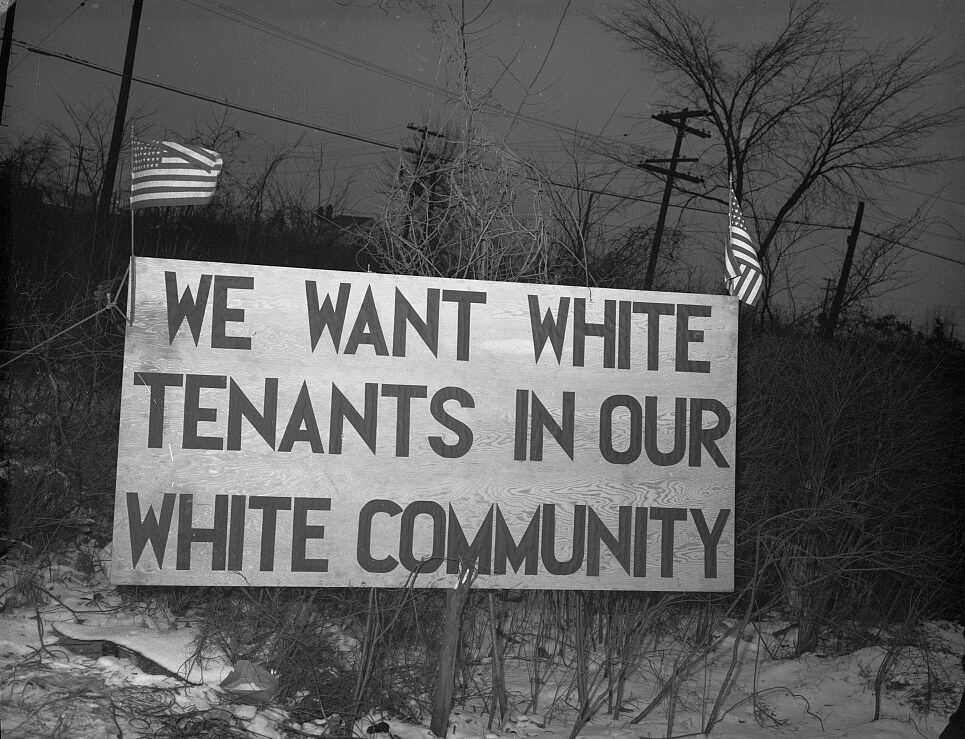 Photograph of sign outside of housing community which reads: "We want white tenants in our white community."