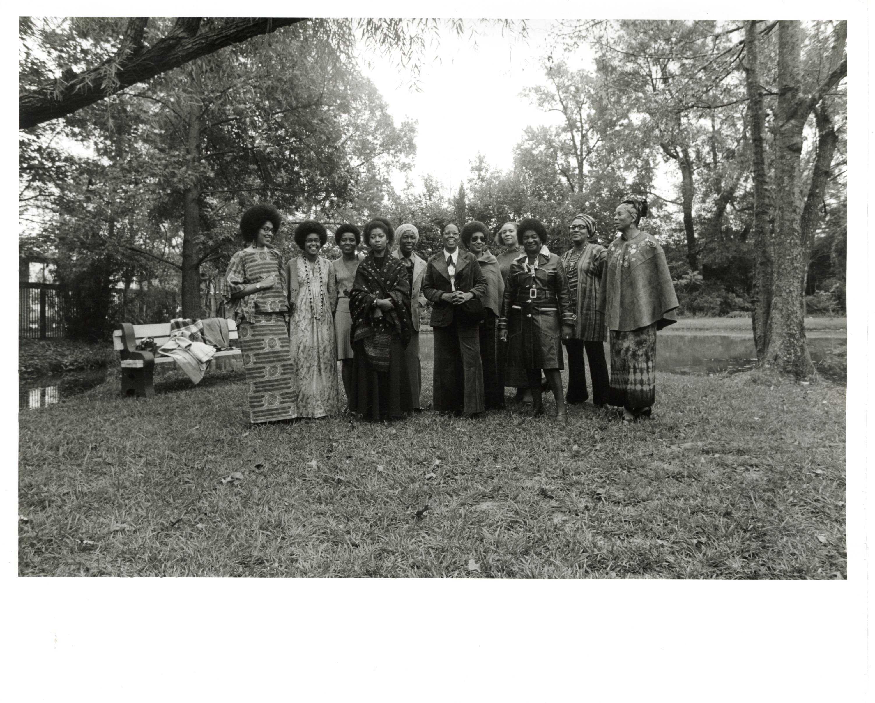 Black and white group portrait of Malaika Wangara, Linda Bragg, Carole Clemons, Alice Walker, Mari Evans, Gloria Oden, June Jordan, Carole Clemmons, Marion Alexander, Margaret Danner, Audre Lorde, and Margaret Burroughs, at the Jackson State Botanical Garden