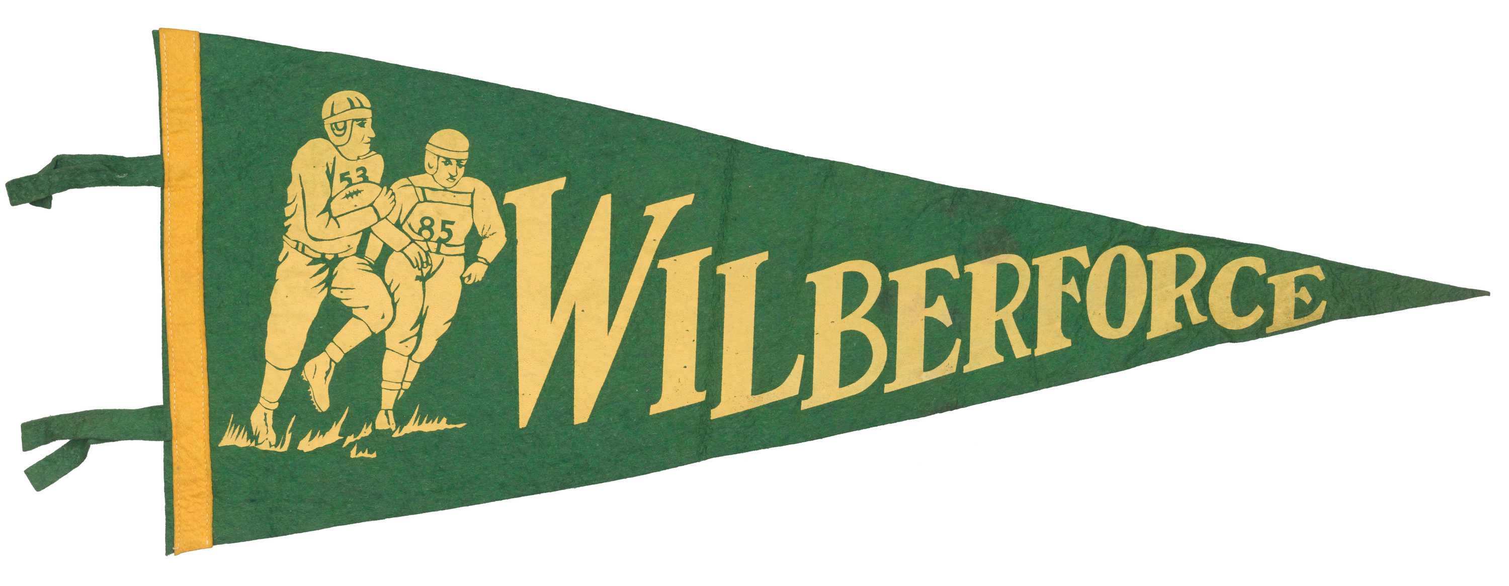 A university pennant forest green in color with a yellow strip of felt at its base. There is yellow stylized text down the center of the pennant which reads [Wilberforce]; to the left of the text is the stylized image of two football players running over sparse clumps of grass.