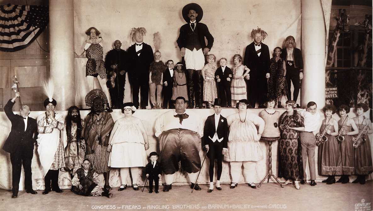 A sepia tone photograph of two rows of different type of performers from the P.T. Barnum Museum.