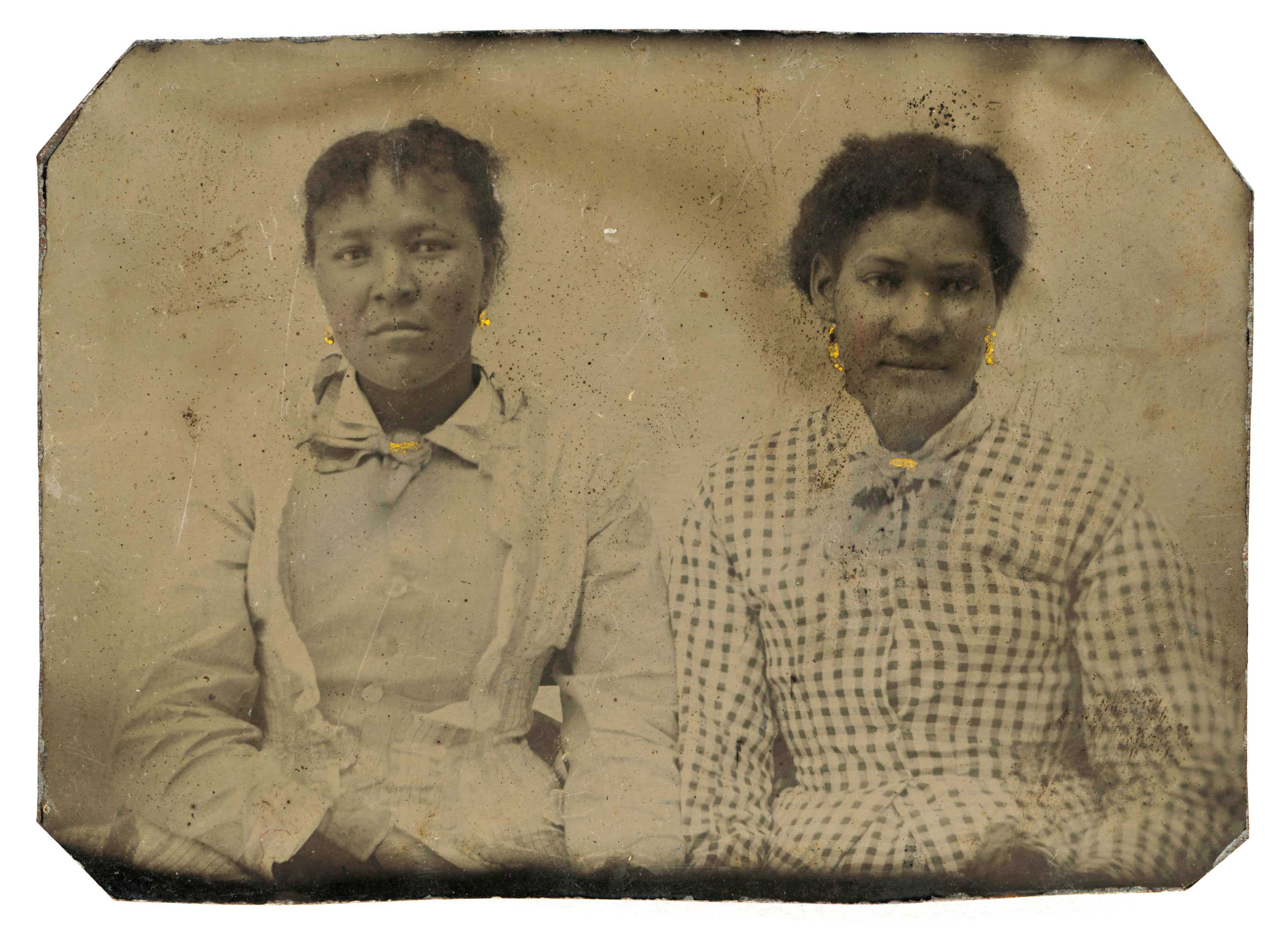 Tintype of two women wearing gold-painted earrings and kerchief pins.