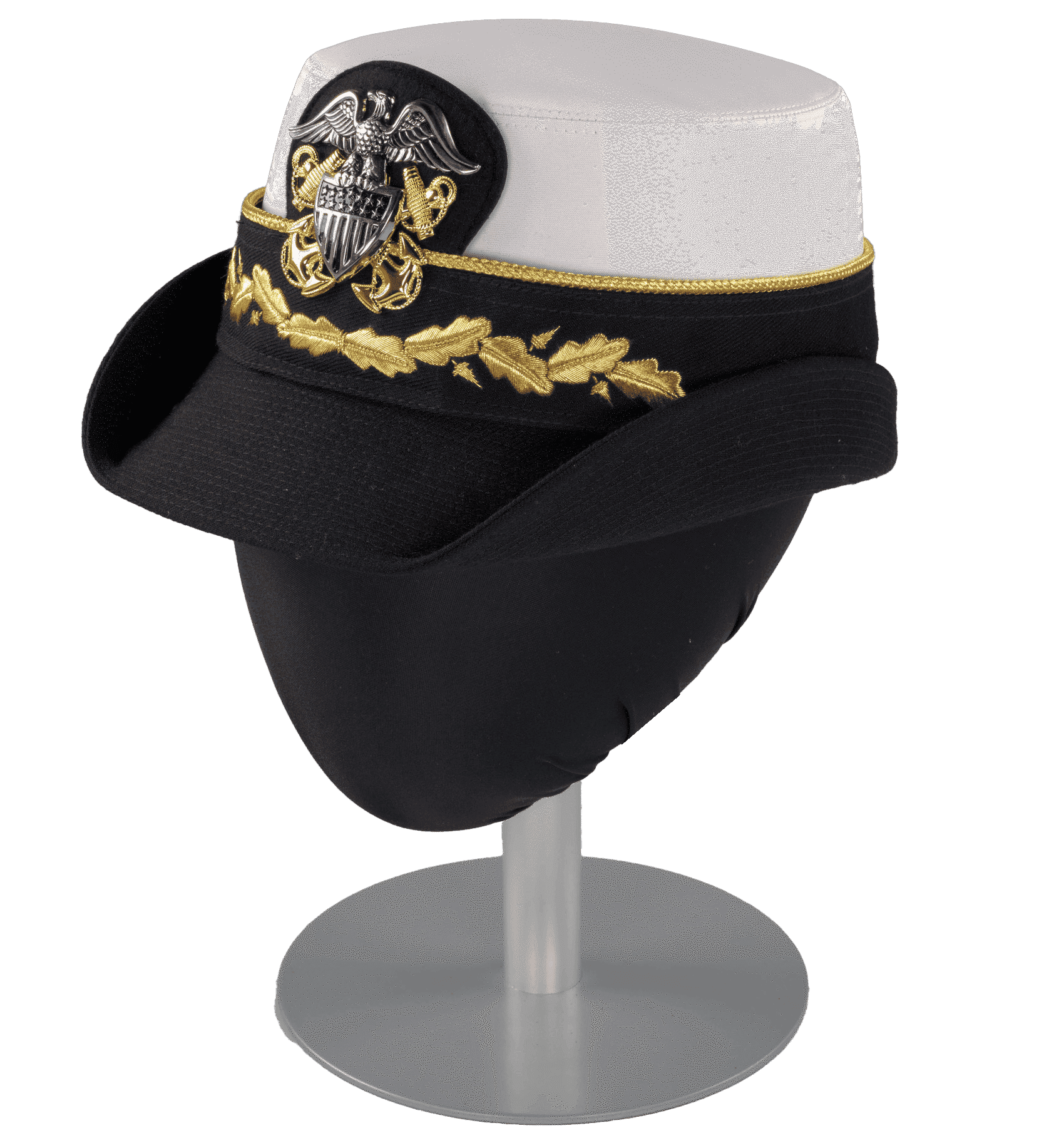 A US Navy dress uniform hat (a) worn by Admiral Michelle Howard as commander with a white waterproof fabric crown and a black canvas brim, with a hat band (b) featuring a US Navy insignia pin (c). The brim of the hat is stiffened, with both sides fixed in a turned up position. The interior of the hat is lined with black waterproof plastic with the manufacturer's name "Kingform Cap / De Luxe / NEW YORK" stamped on it in gold. The sides of the crown are lined in black synthetic satin fabric. There is a size "23" tag at the interior center back and a tag at the interior proper left back with style and military regulation information. 

The hat band (b) attaches to the hat (a) with four (4) metal snaps, one at the front and back and one on each side. The band is made from black canvas trimmed on the top edge with gold braid. A length of the black canvas cut on the bias is looped around the center back portion of the band and stitched to it at the bottom edge, with the tails left dangling below the brim of the hat (a). An oak leaf and acorn design is embroidered in metallic gold thread at the center front of the band. A piece of black felt backed in leather with rounded edges protrudes from the center front top edge of the band.

A large silver and gold metal US Navy insignia pin (c) with two screw back fasteners is attached to the black felt on the hat band (b). The eagle and shield are in silver, while the two crossed anchors are in gold.