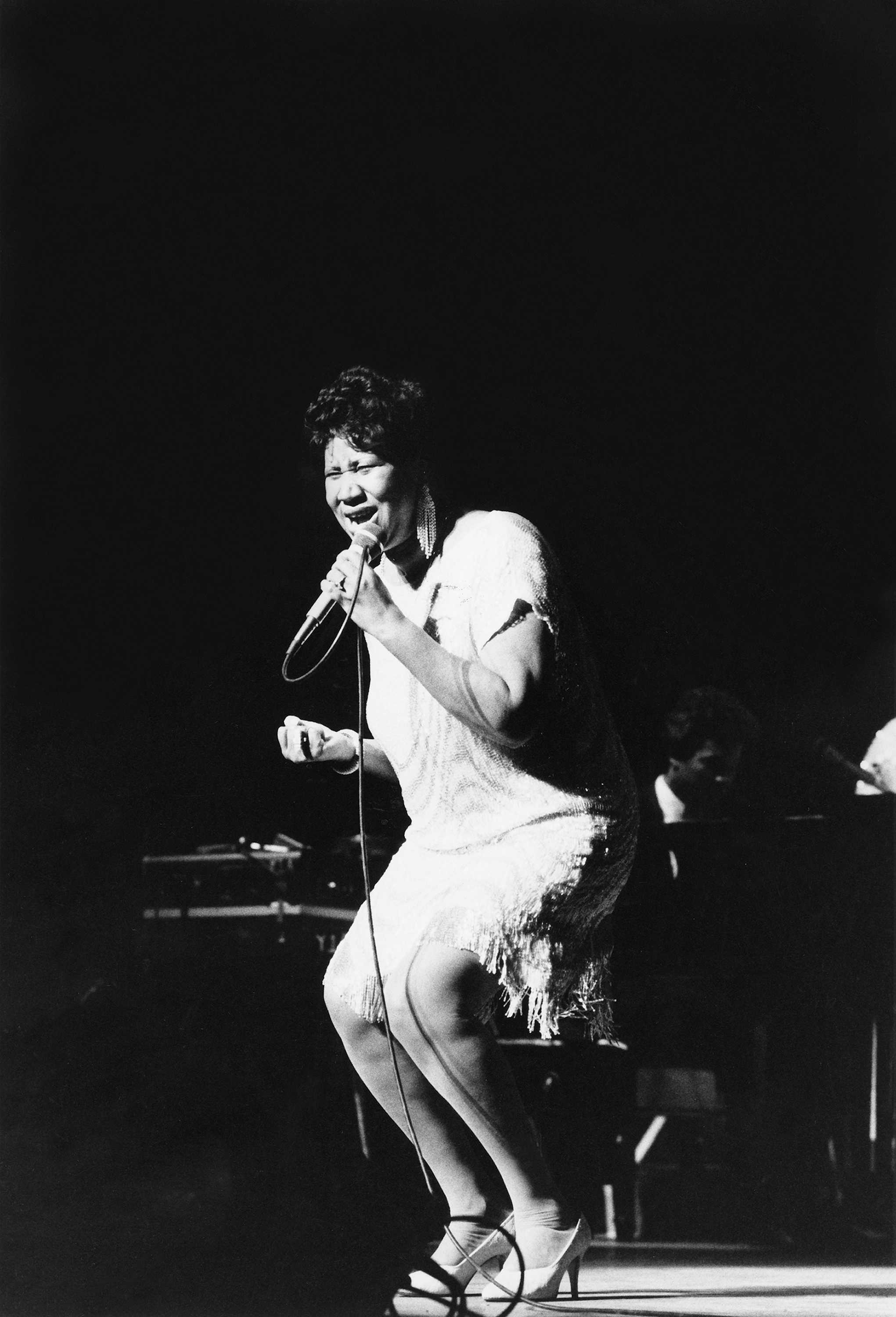 Black and white photograph of Aretha Franklin performing on stage