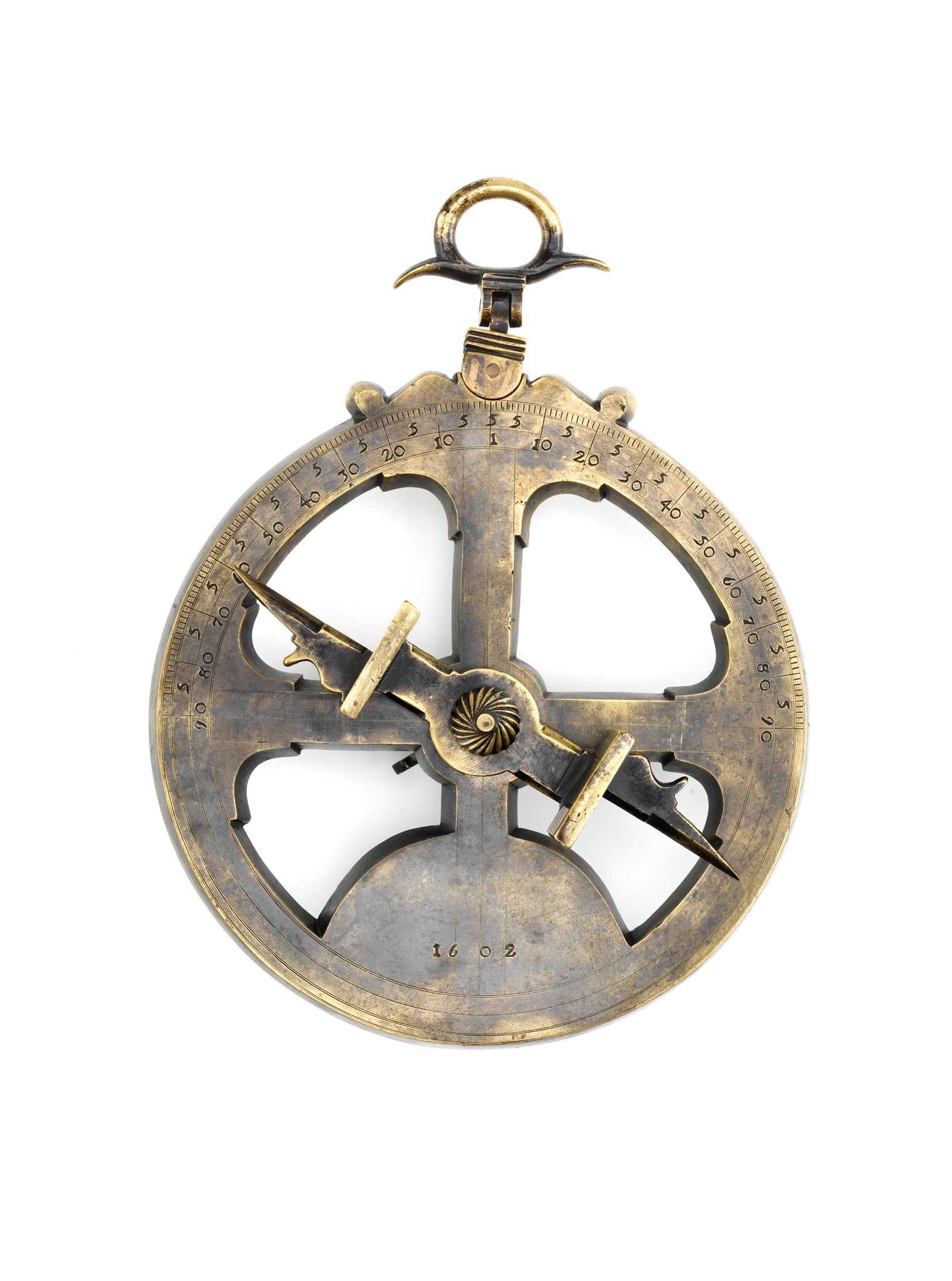 An astrolabe on display against a white background. The astrolabe has a gold and gray tarnish with the numbers 1602 pressed into the bottom.