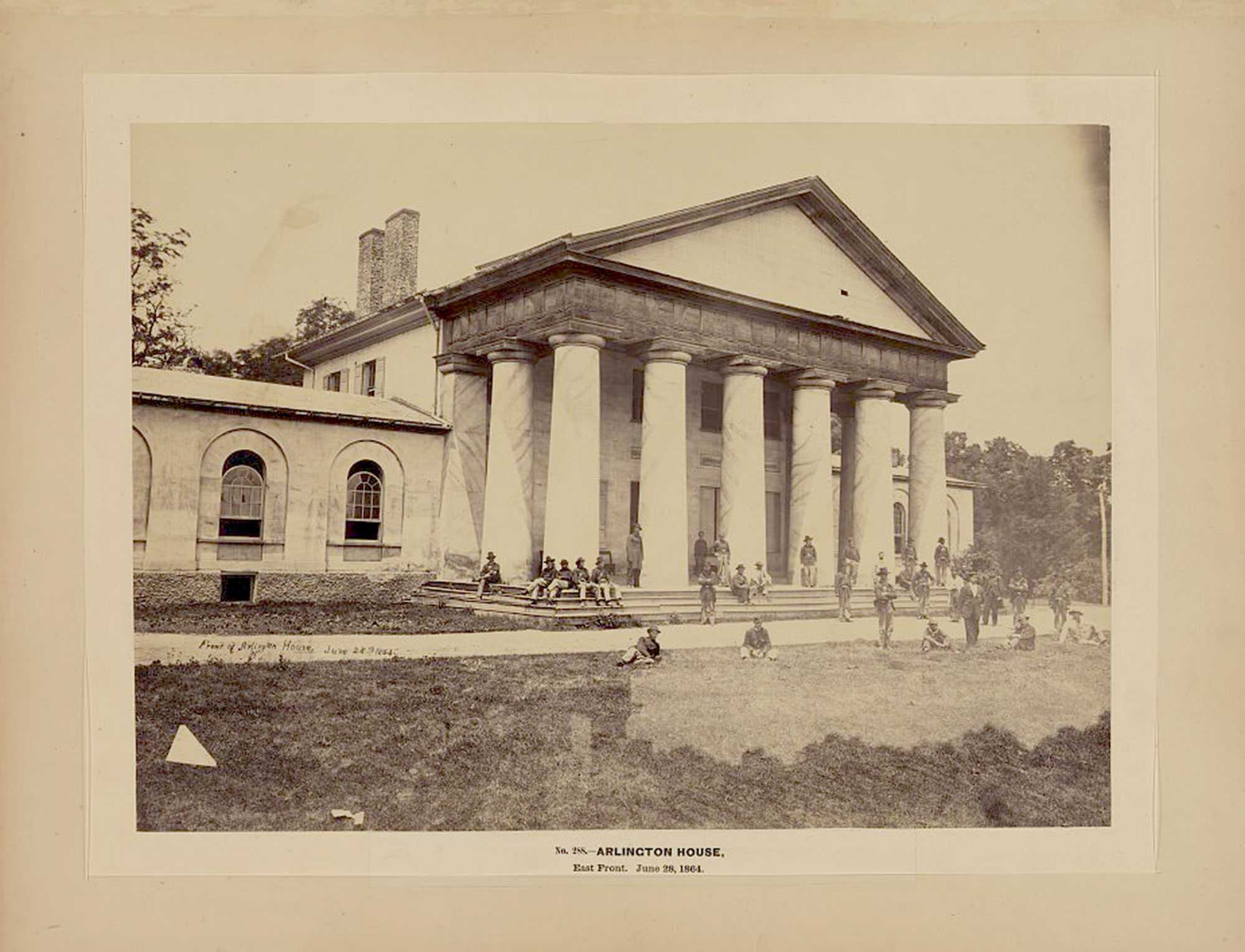 Photograph of Arlington House with people gathered on the steps and lawn, dated June 28, 1864.