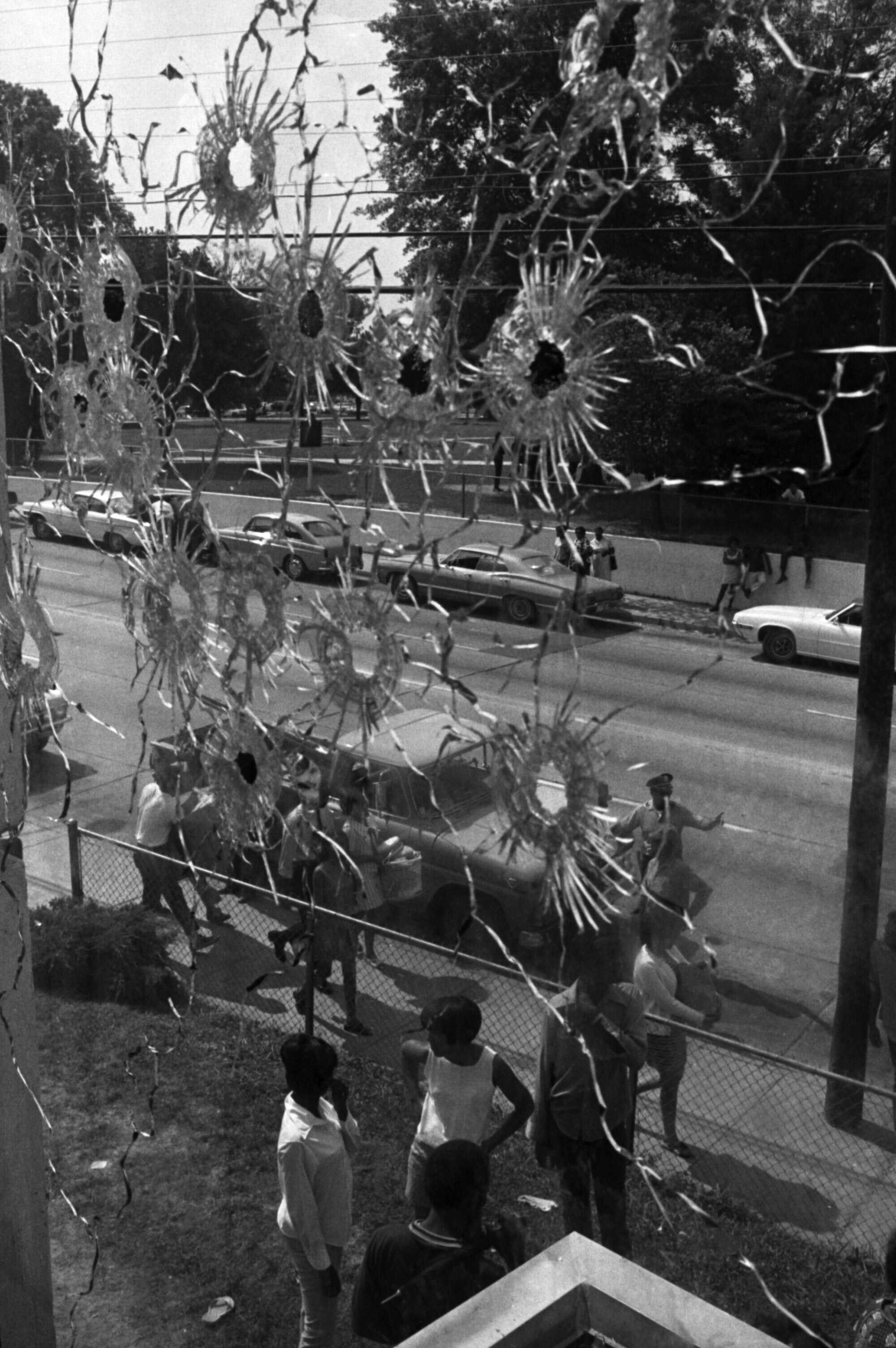 A photo of the inside of a window with bullet holes.