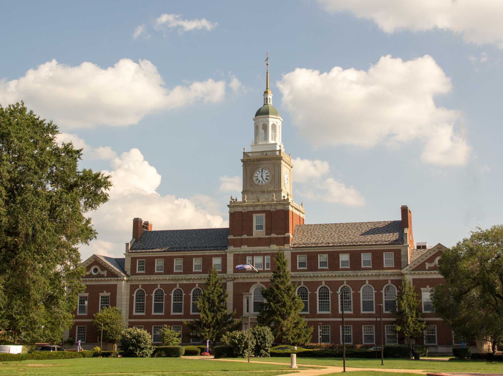 The Founder's Library at Howard University is a colonial style, brick building with a large clock tower in the middle.