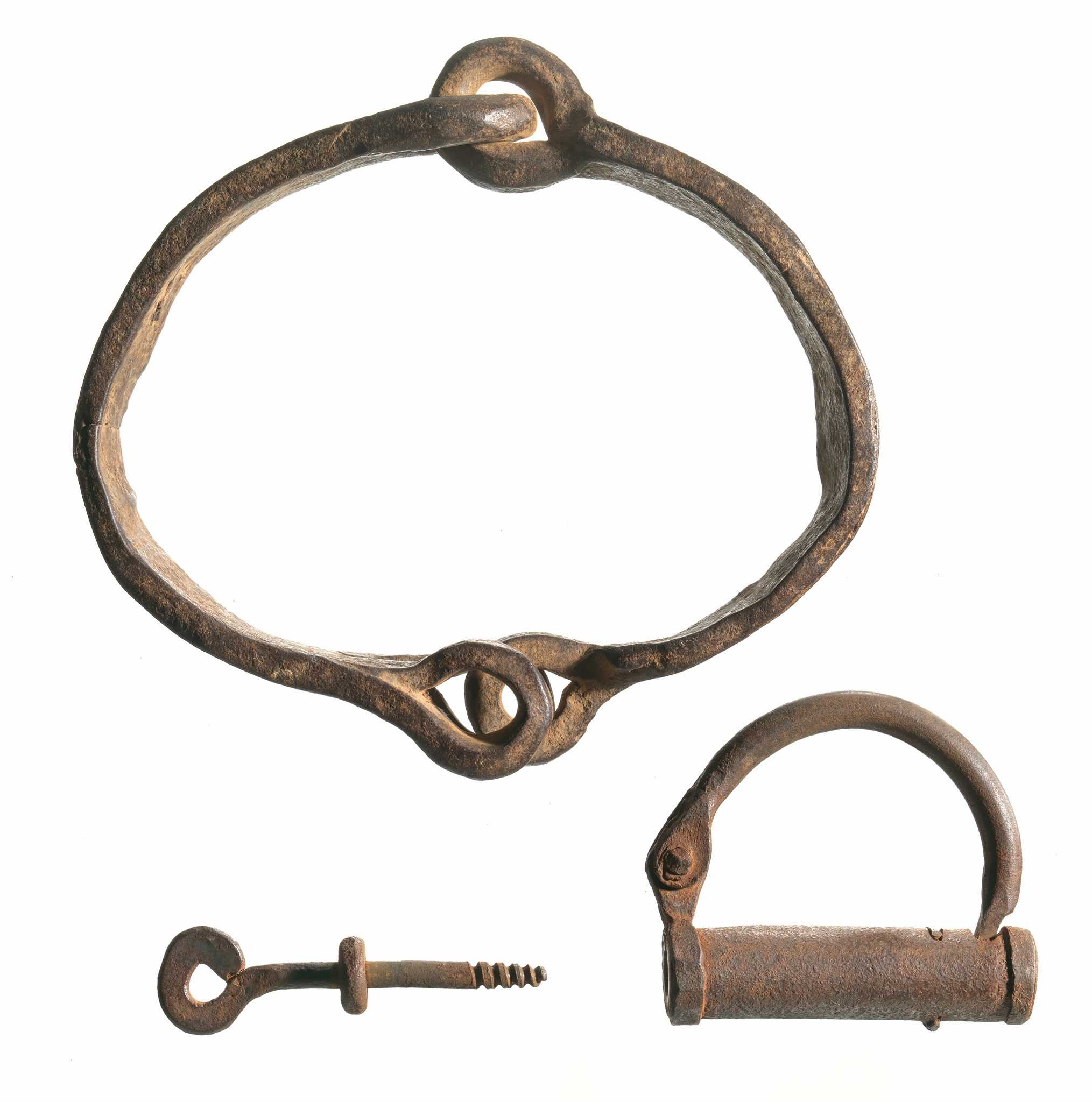Wrought iron collar with a three inch locking device and a three inch key. The collar is made up of two pieces of iron attached with a hinged, chain link back. Each end of the collar has an eyelet that can overlap and the lock can be inserted in to. The lock has a cylinder locking mechanism and a curved shackle hinged on one side. The key has an eyelet on one end and a shoulder in the middle of the shaft. The teeth of the key are threaded like a screw.