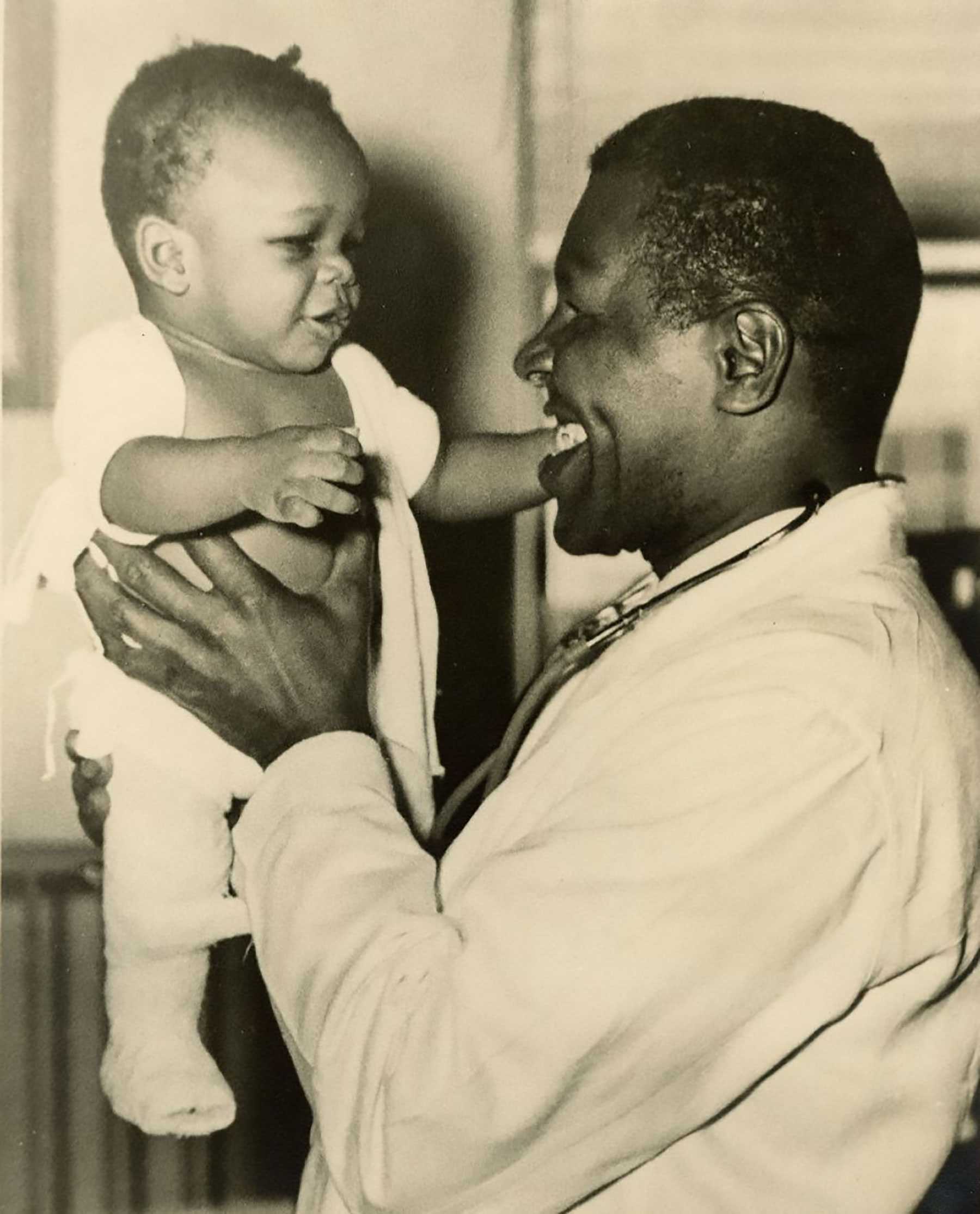 Phhoto of a smiling man holding a baby, illustrating a moment of joy and connection.