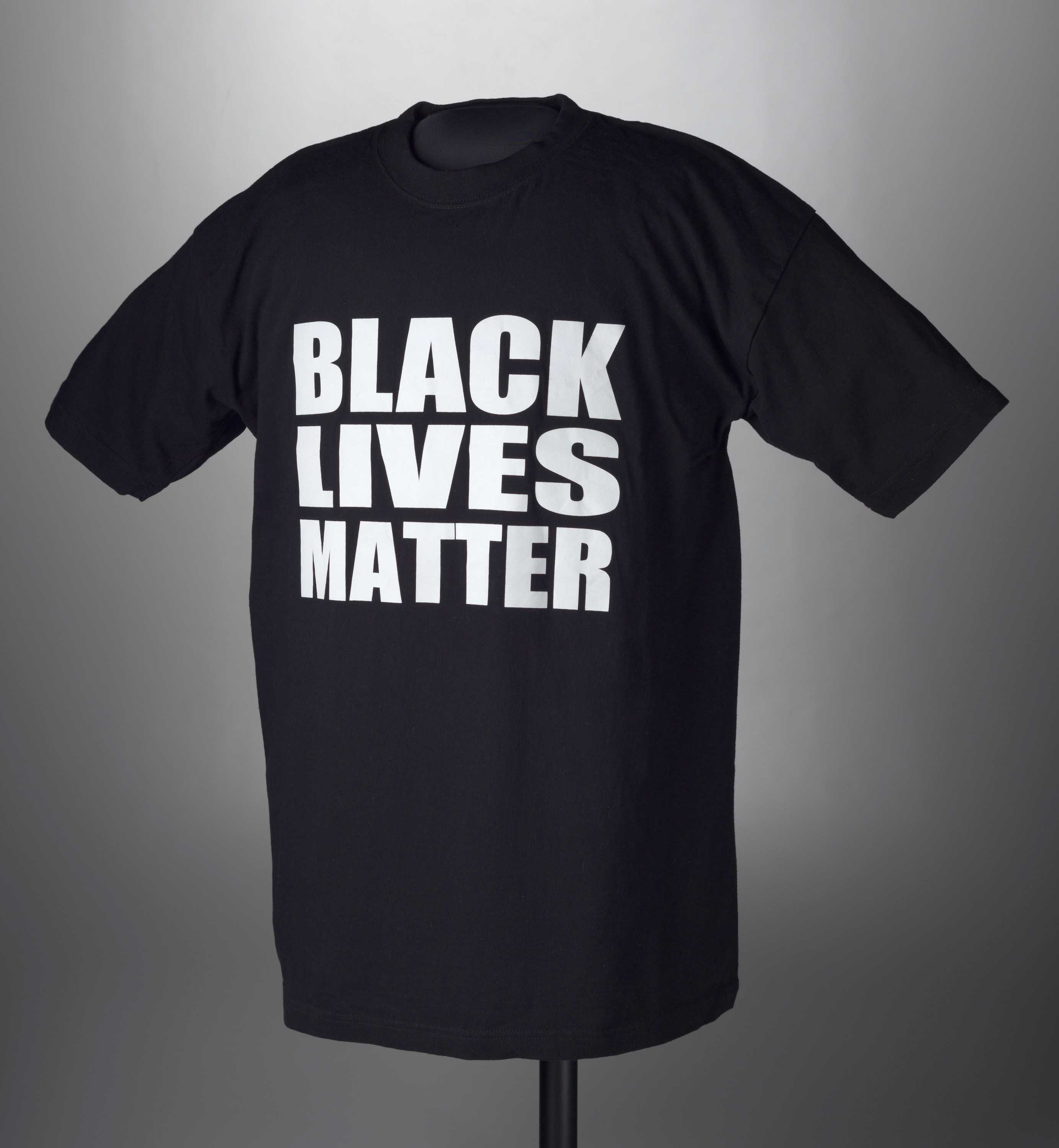 A black T-shirt with white lettering on the front. The text on the shirt reads “BLACK / LIVES / MATTER.”