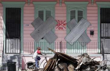 A child rides past debris in New Orleans