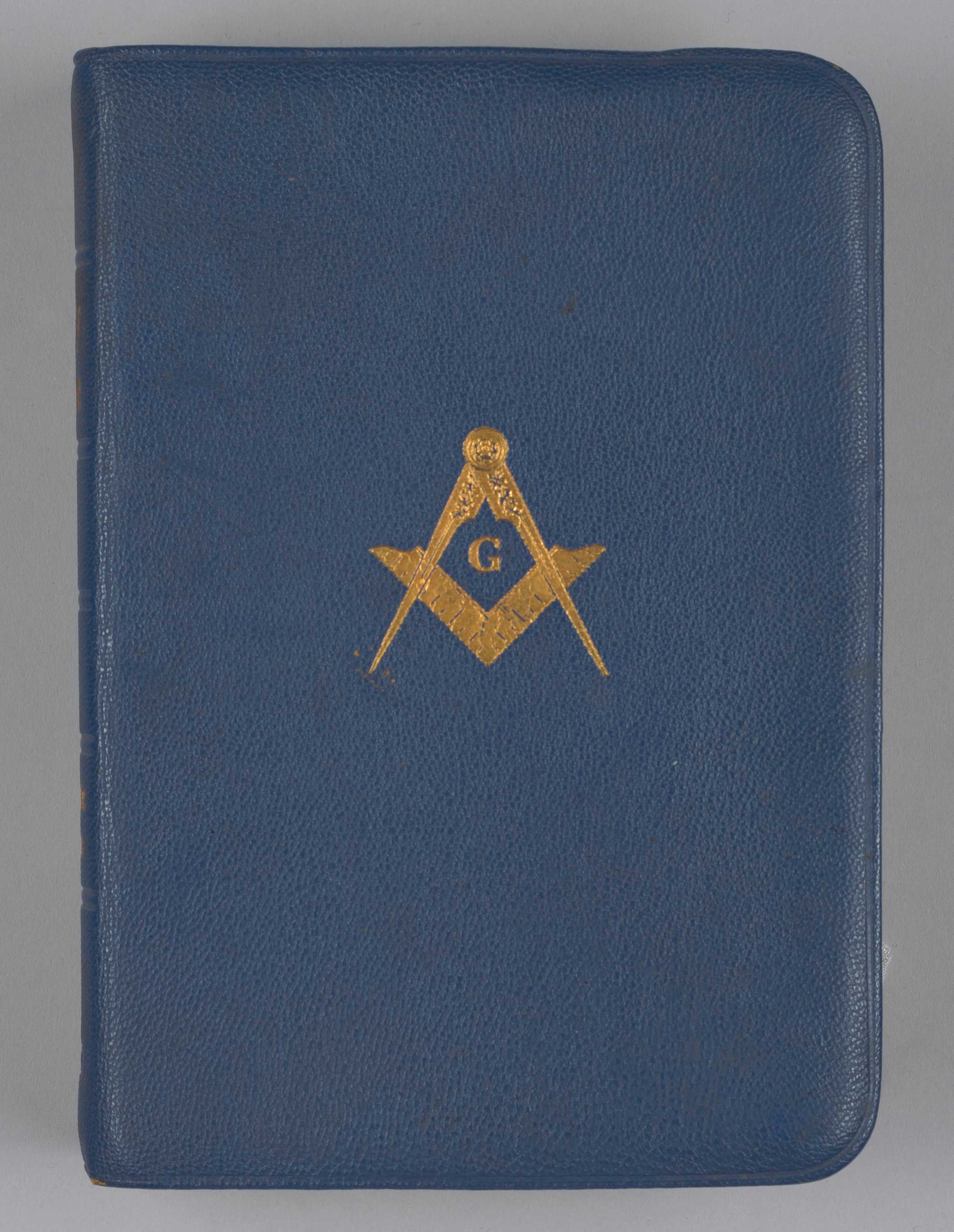 This publication of The Holy Bible is bound in blue leather with the symbol of Freemasonry on the front.