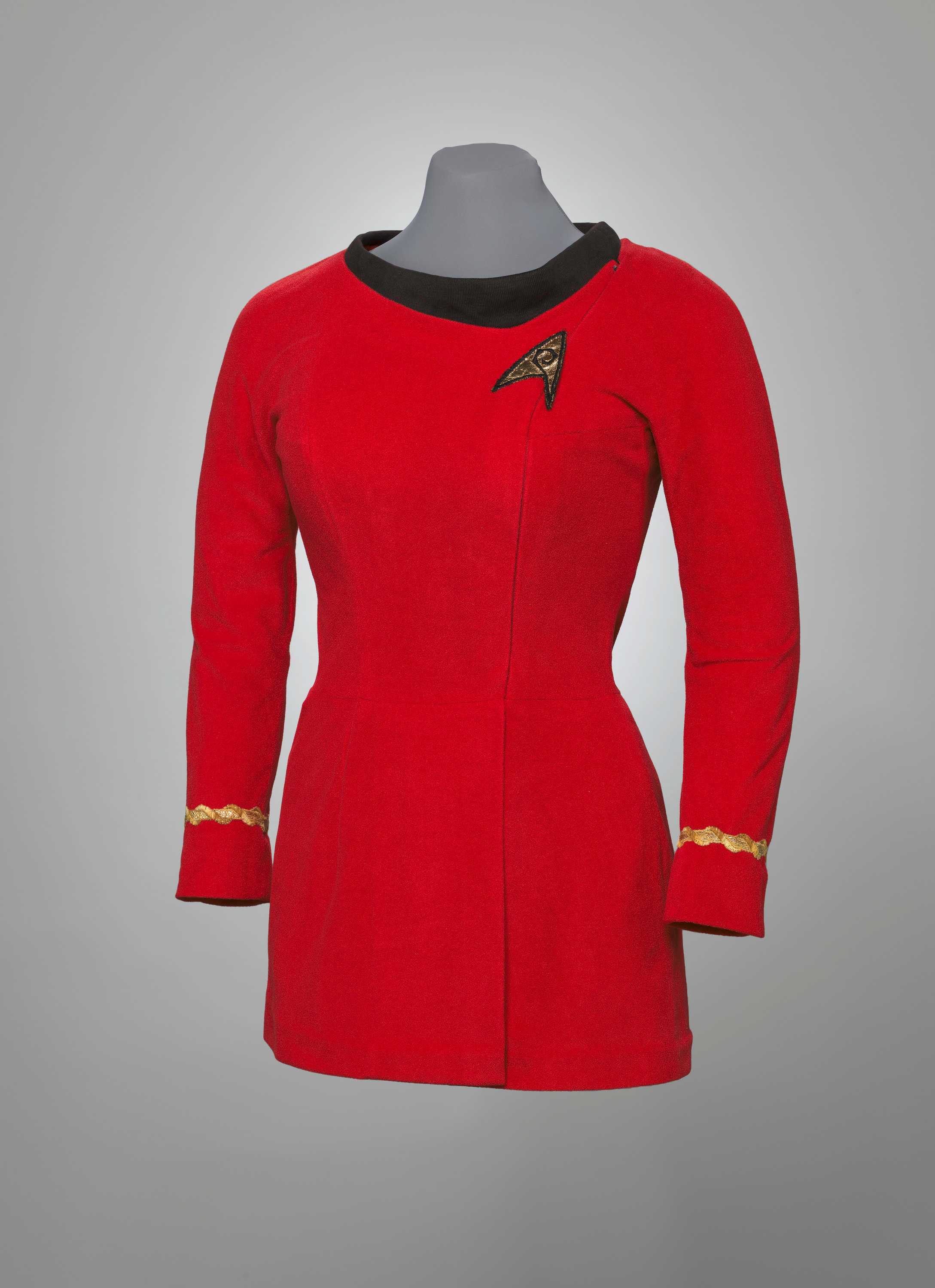 The bright red Starfleet uniform has 3/4th long sleeves and the Starfleet symbol on the right side of the collar.
