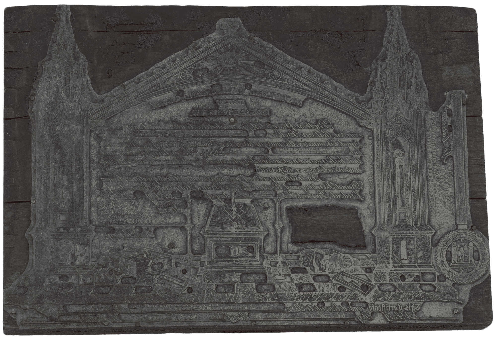 A metal printing plate mounted on a wood block used to print lodge certificates.