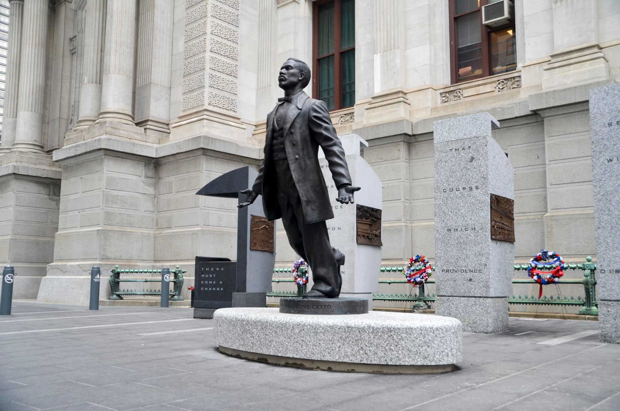 Bronze statue on granite base, five granite pillars, stainless steel ballot box on granite base